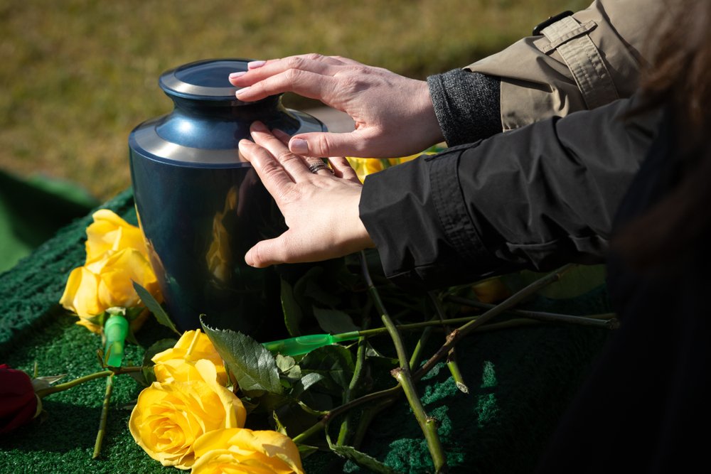 Manos sobre una urna funeraria. | Foto: Shutterstock