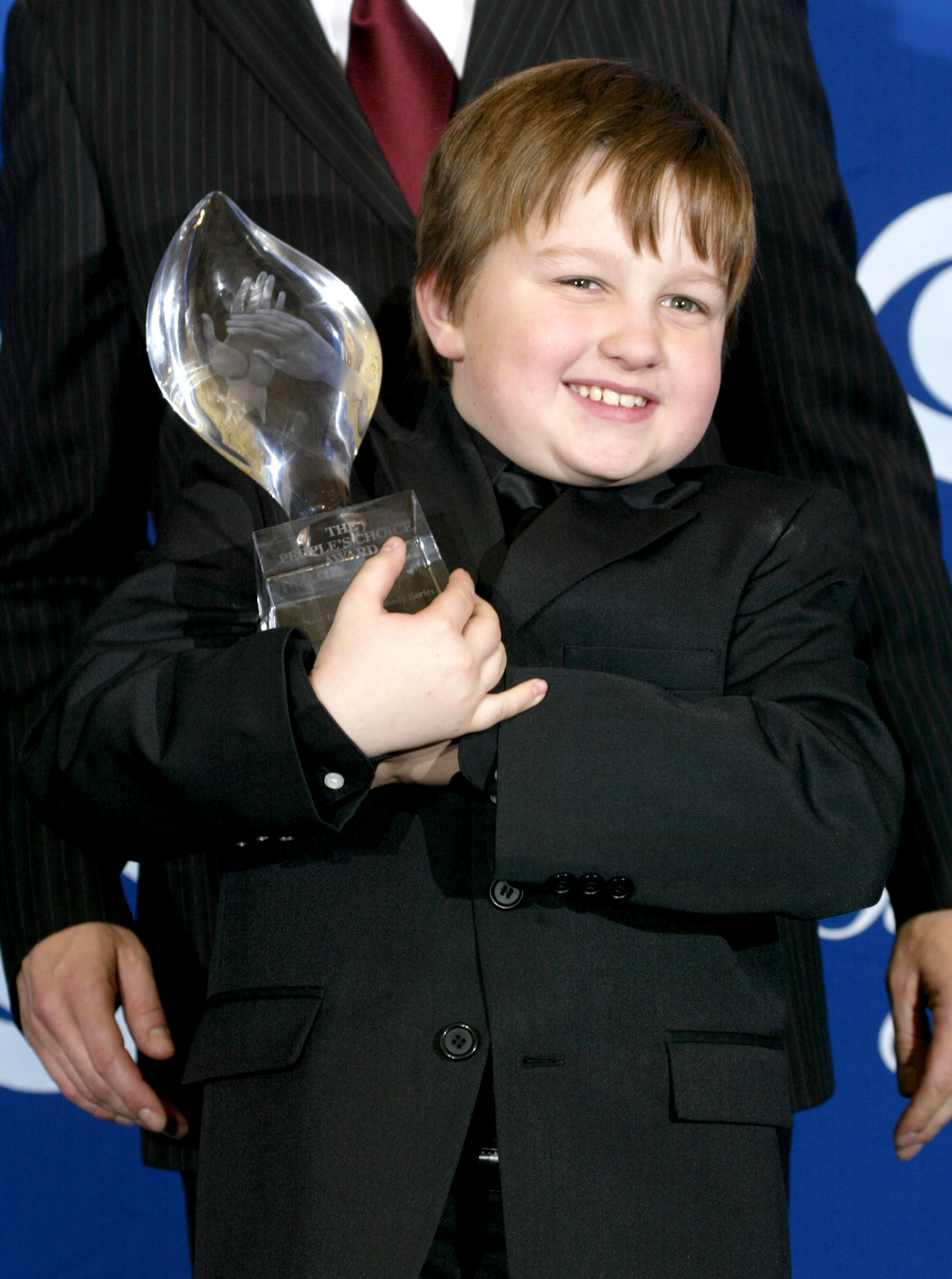 Angus T. Jones holding his award at the People's Choice Awards for his role on "Two and a Half Men""Two and a Half Men" in Los Angeles in 2004 | Source: Getty Images