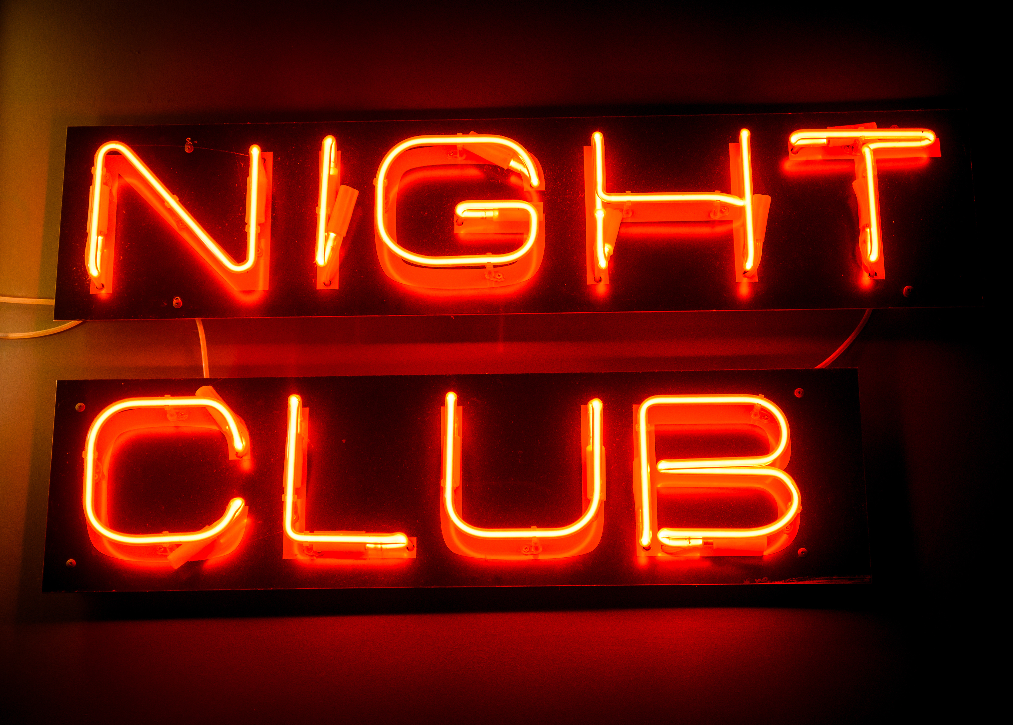 Nightclub neon sign hanging on the wall. | Source: Shutterstock