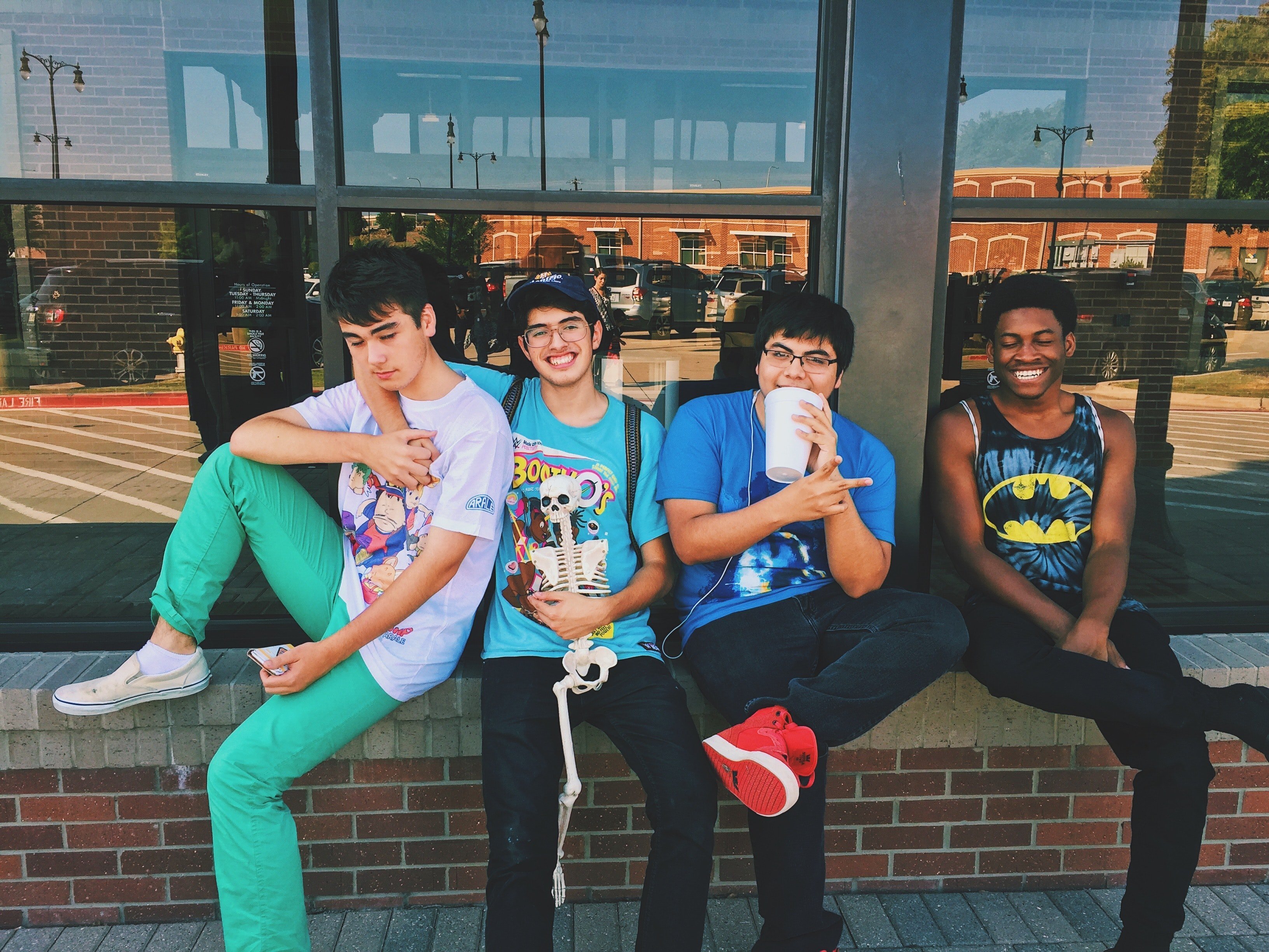 Boys sitting outside a store having fun. | Source: Pixabay