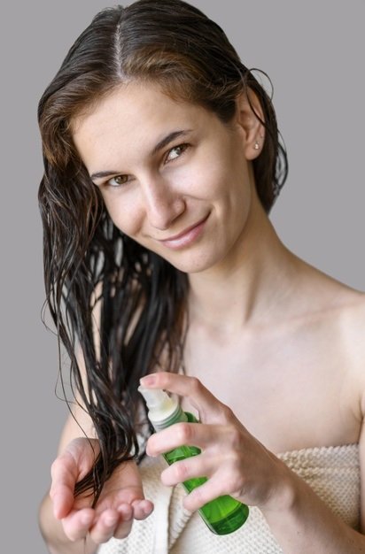 Mujer usando aceite capilar. | Foto: Freepik