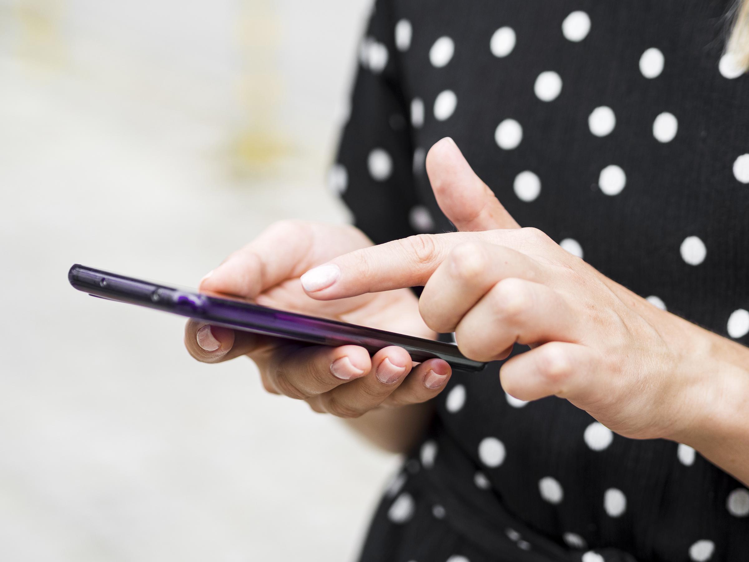 A young woman reading the texts on her phone | Source: Freepik