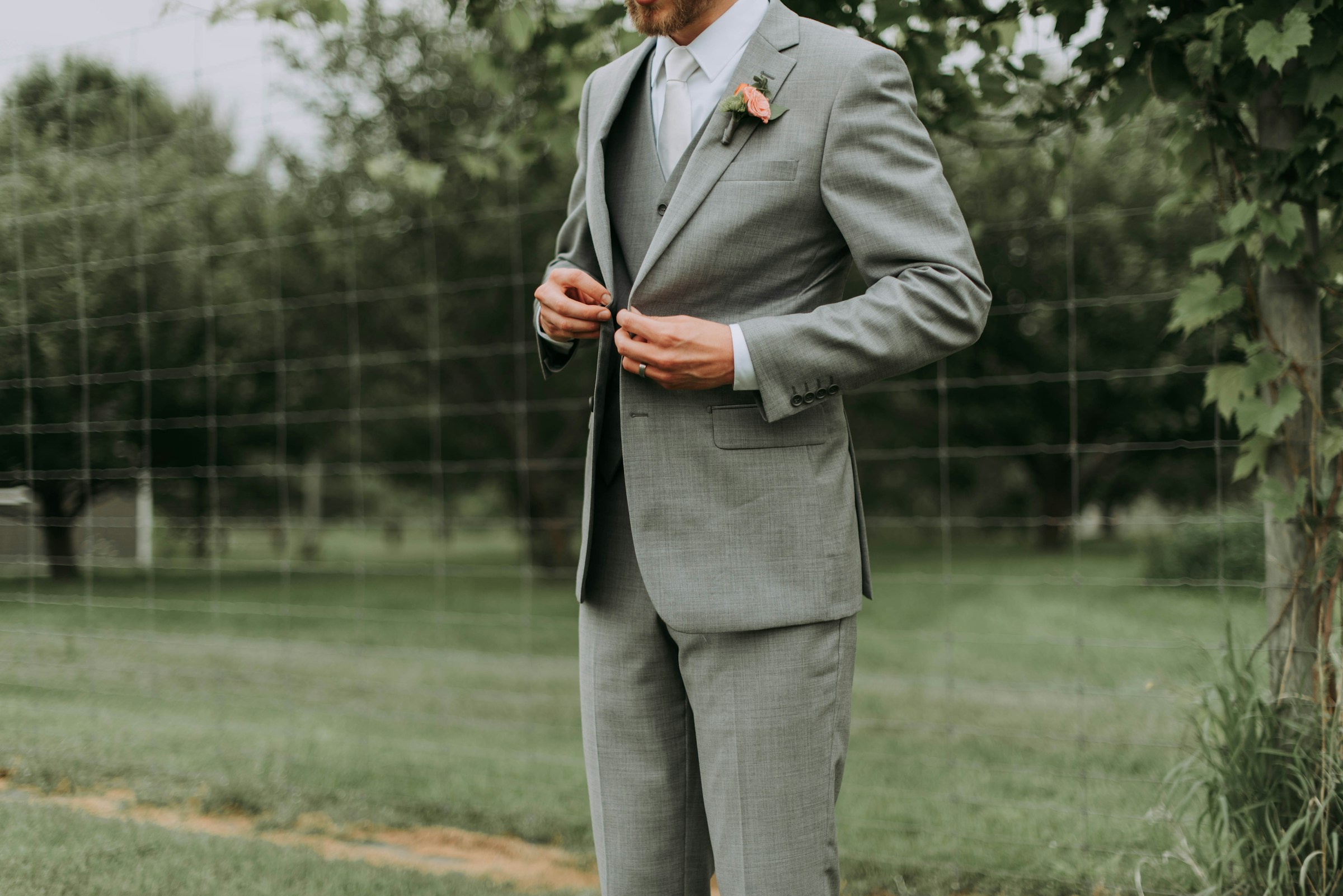 A close-up shot of a groom adjusting his jacket's button | Source: Unsplash