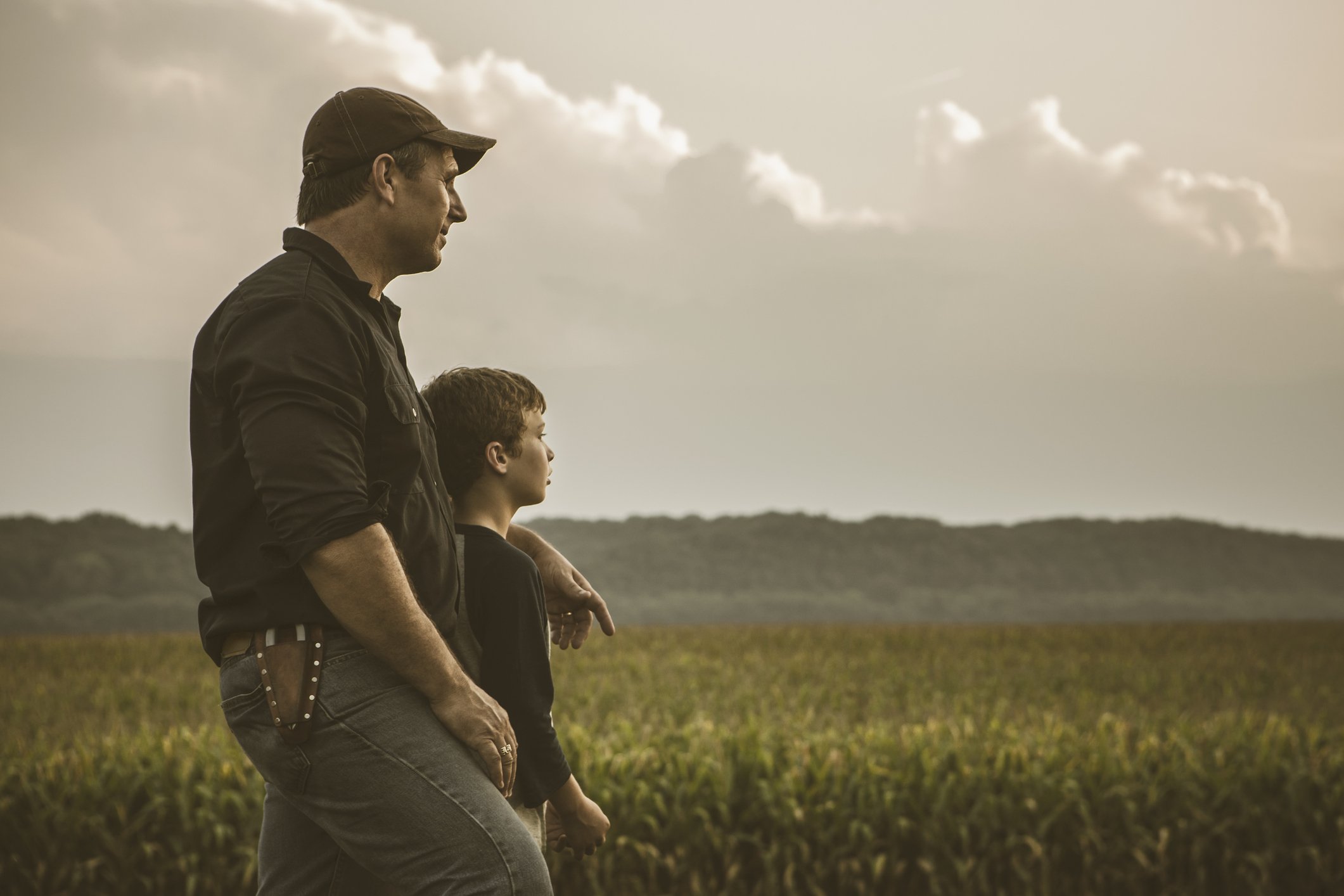 A photo of a father and son overlooking a crop field. | Photo: Getty Images