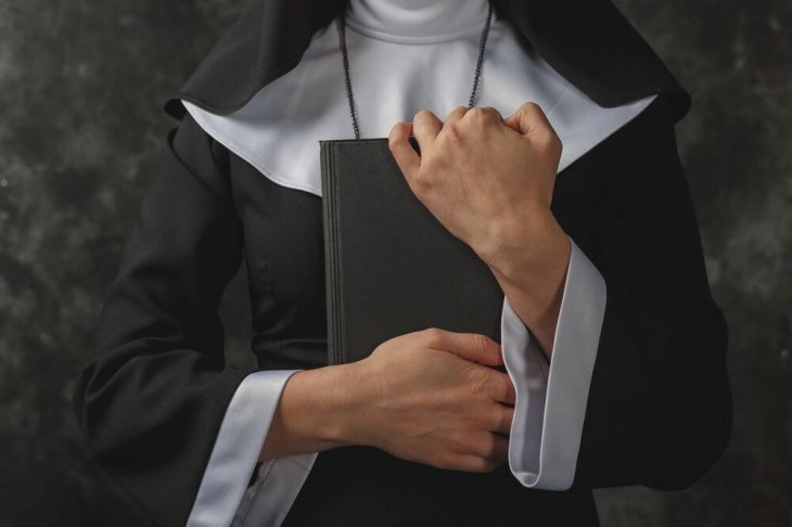 Monja sosteniendo un libro entre sus brazos. | Imagen: Shutterstock Monja sosteniendo un libro entre sus brazos. | Imagen: Shutterstock