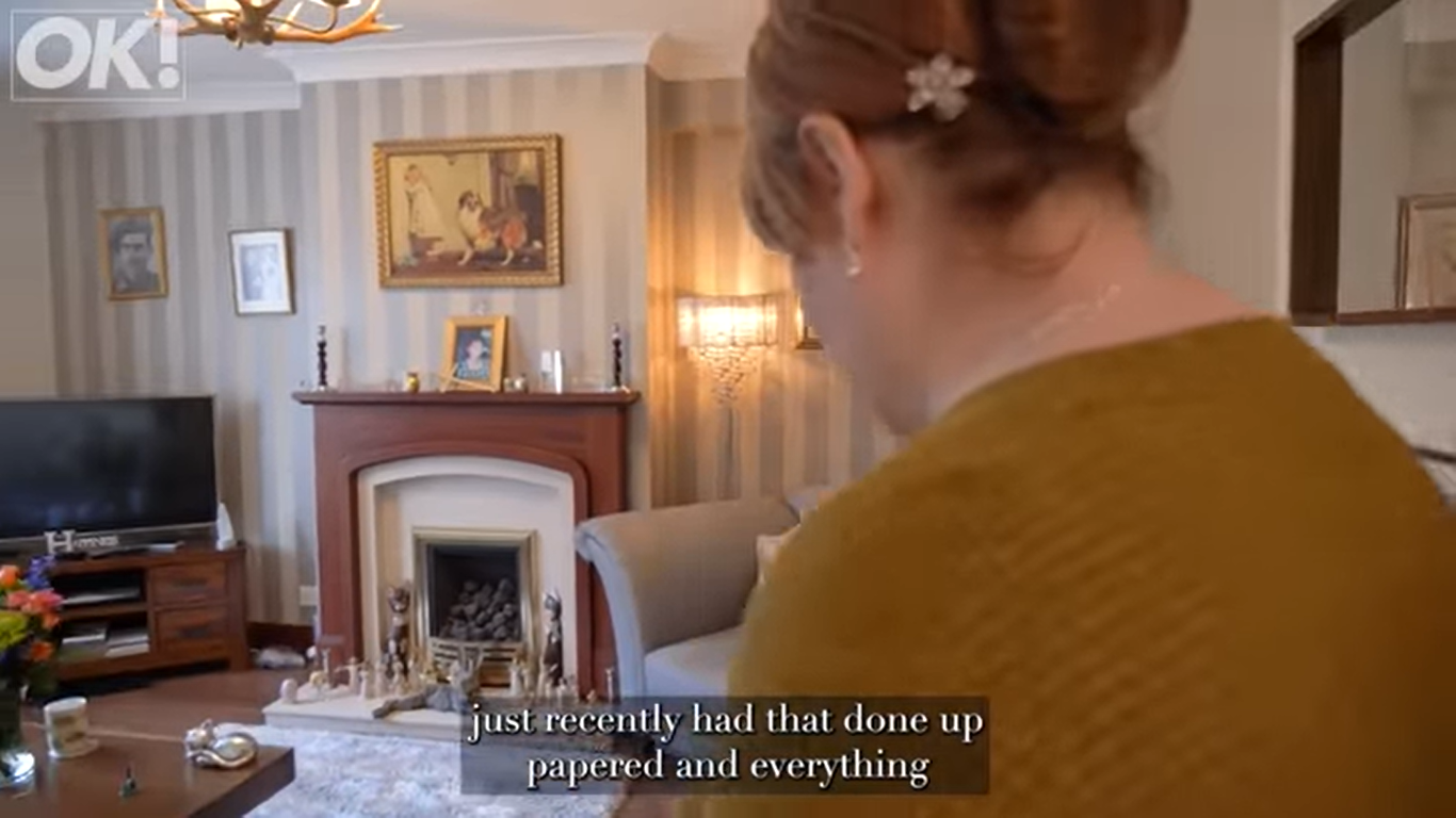 Susan Boyle shows off the living room in her childhood home in Blackburn, Scotland. | Source: YouTube/OK!MagazineUK