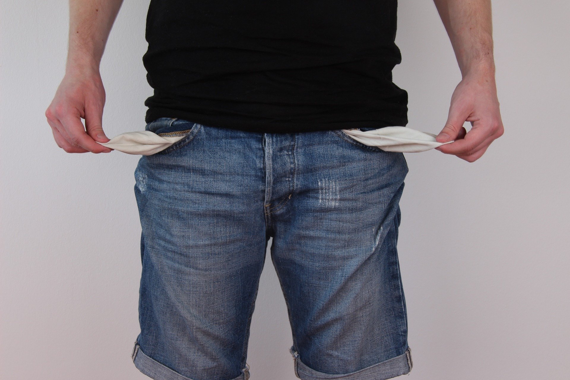 A broke young man shows his empty pockets. | Source: Pixabay.
