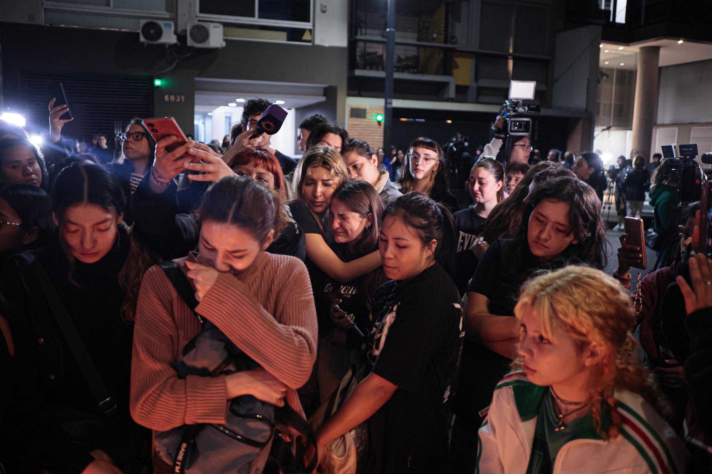 Fans of Liam Payne gathered outside the hotel to sing the band's songs and leave a candle at an improvised altar. | Source: Getty Images