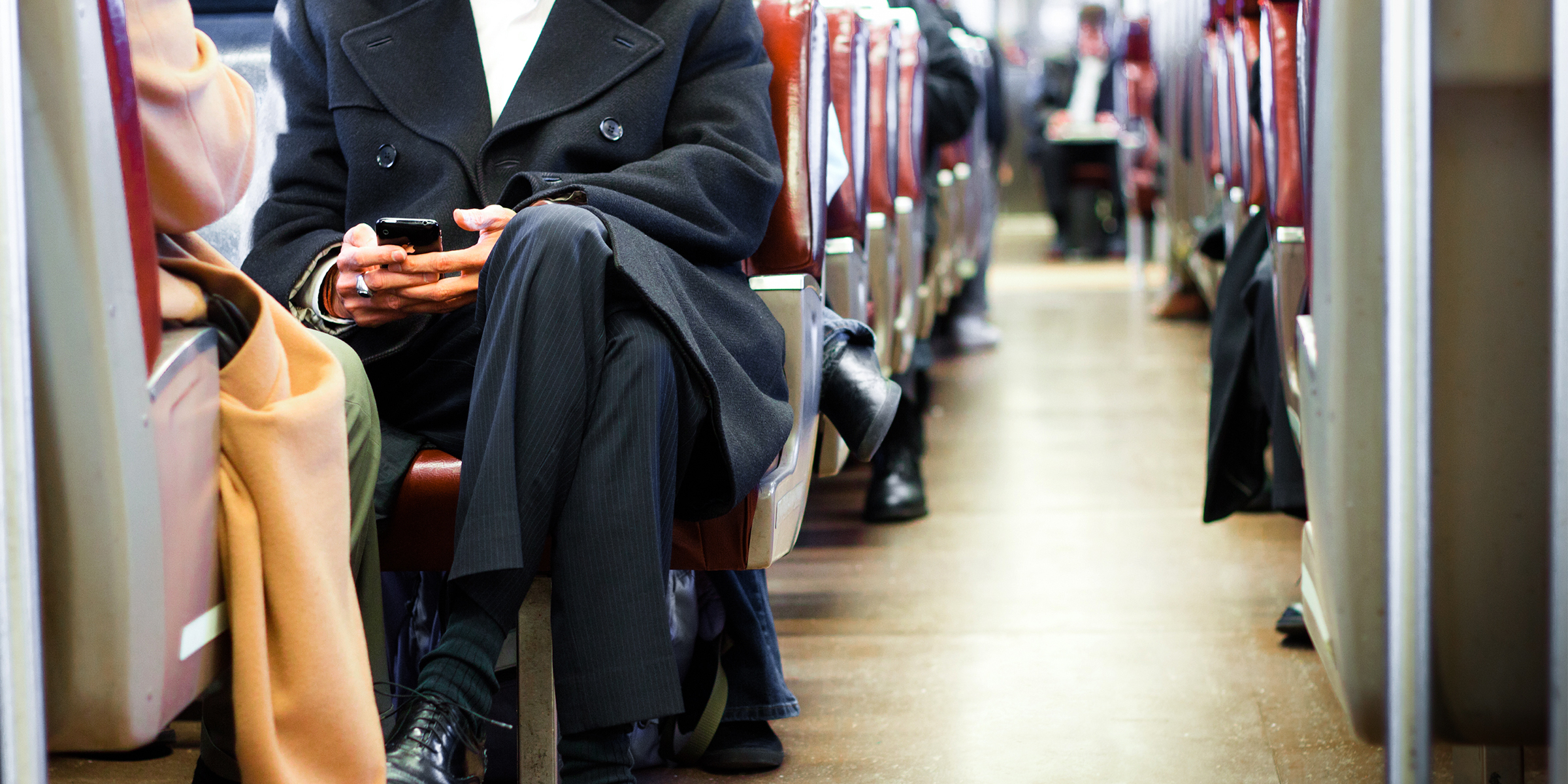 A man in a suit sitting on a busy train | Source: Shutterstock