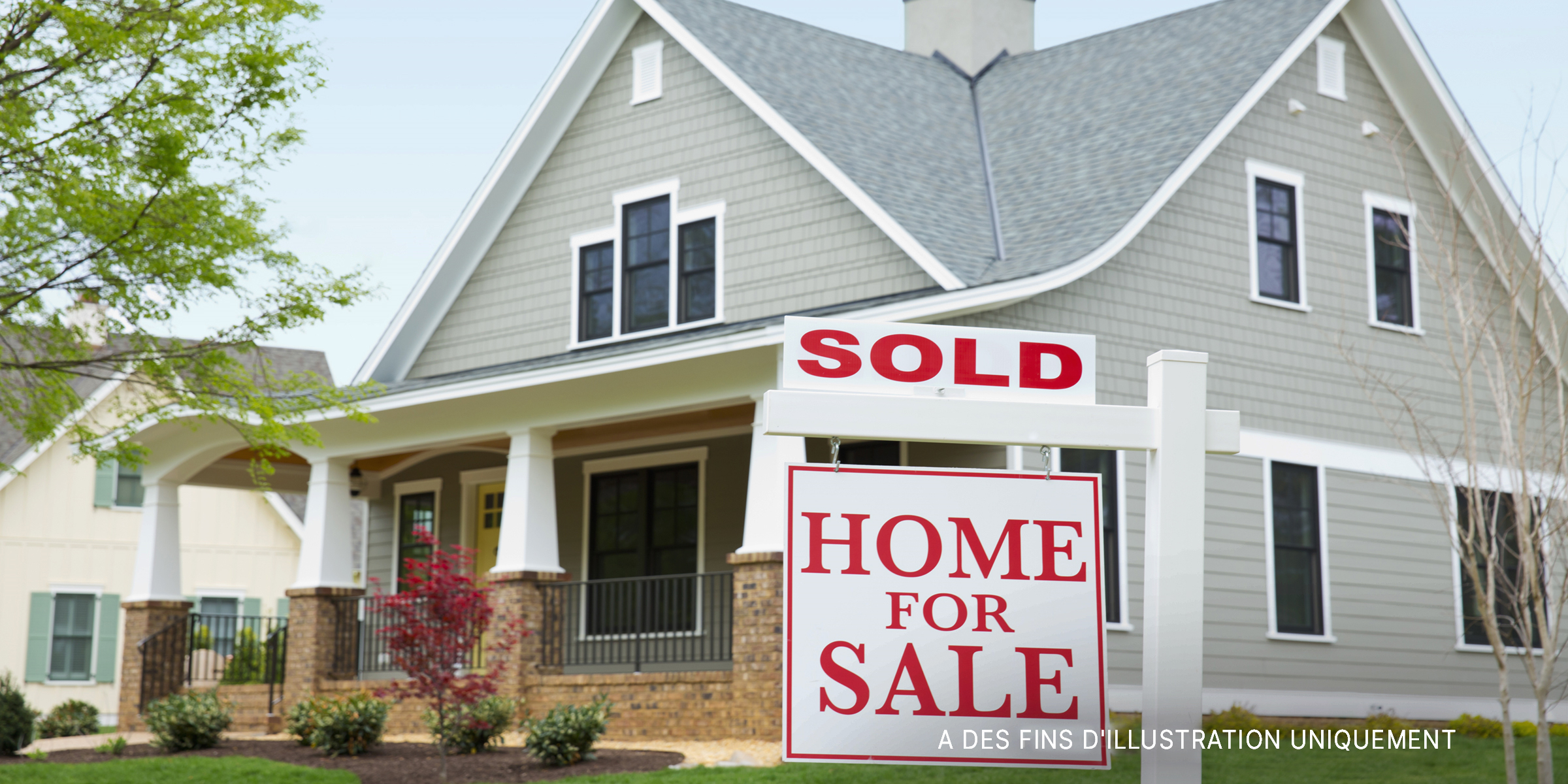 Une maison avec un panneau "Maison à vendre" à l'avant. | Source : Getty Images