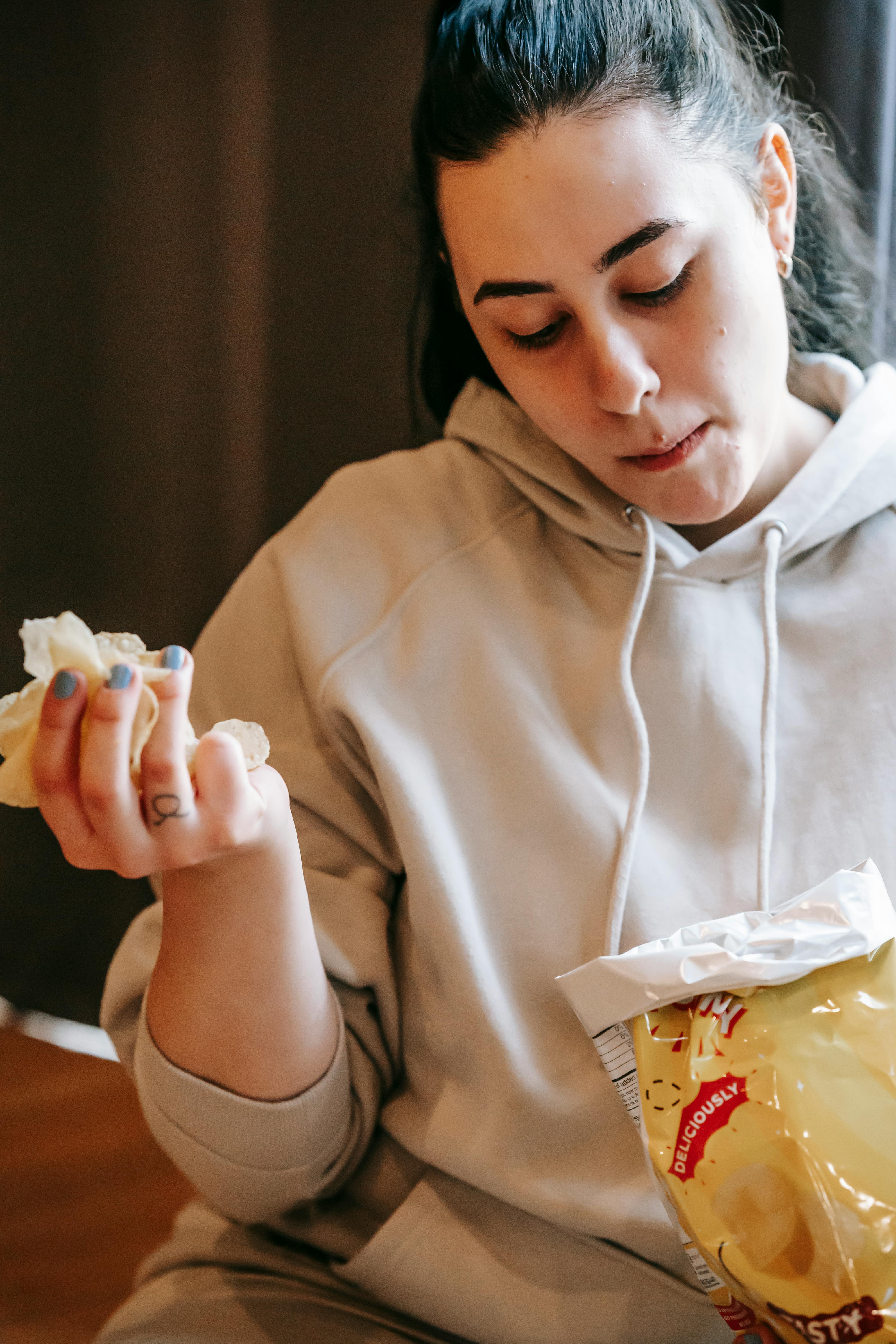 A woman eating chips | Source: Pexels