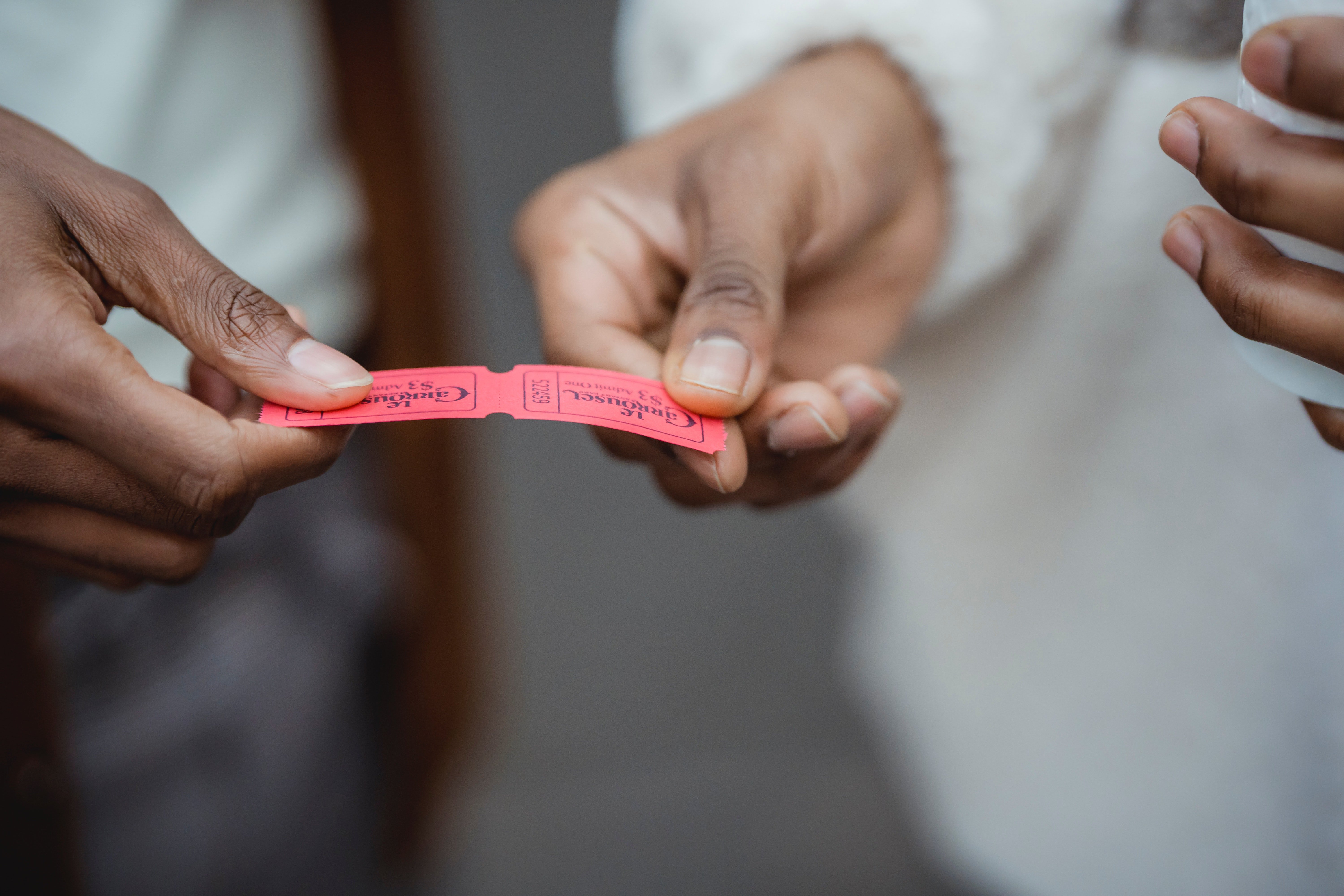 A red ticket in hands. | Source: Pexels