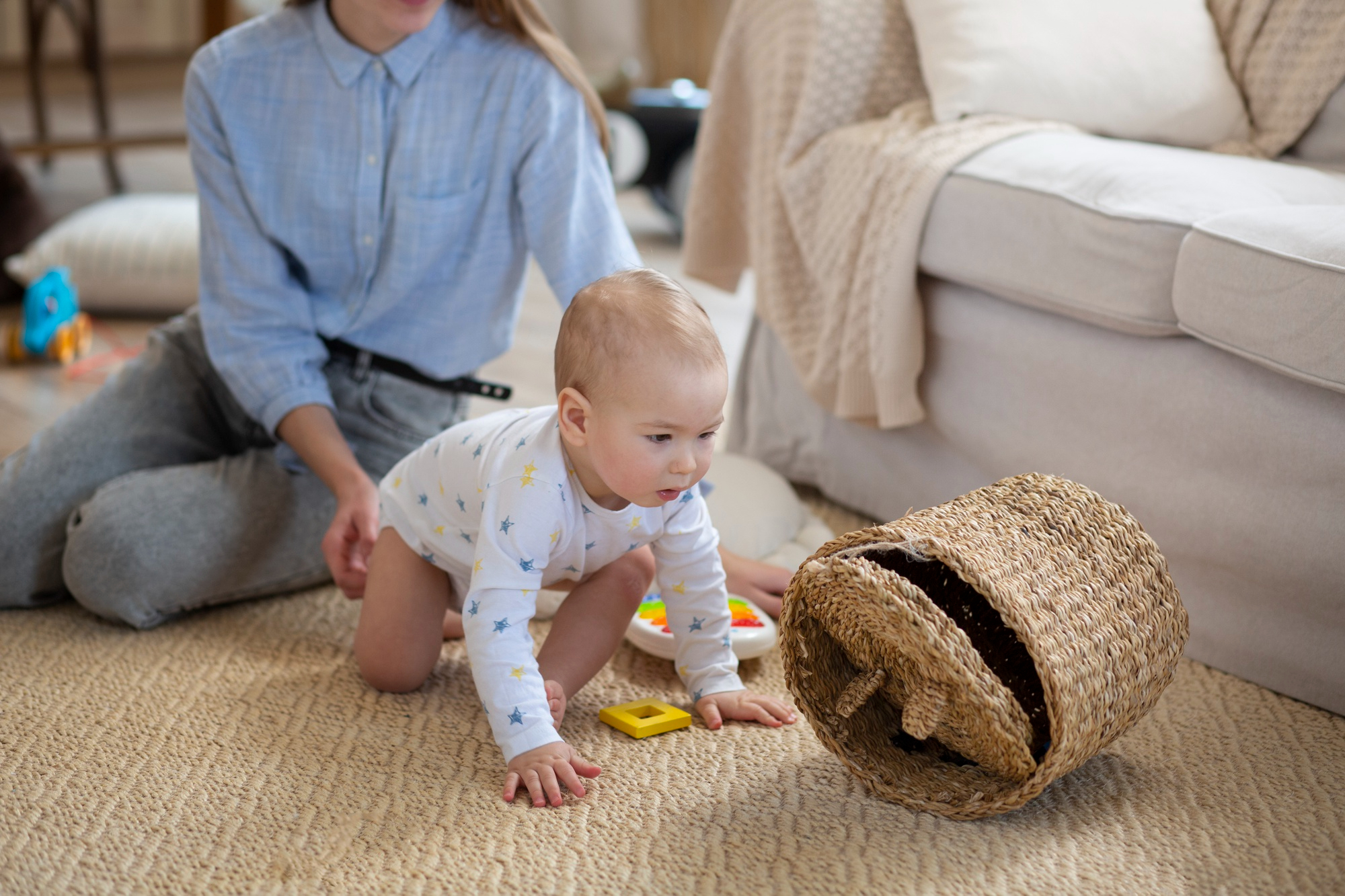 A closeup of a nanny holding a crawling baby in a room | Source: Freepik