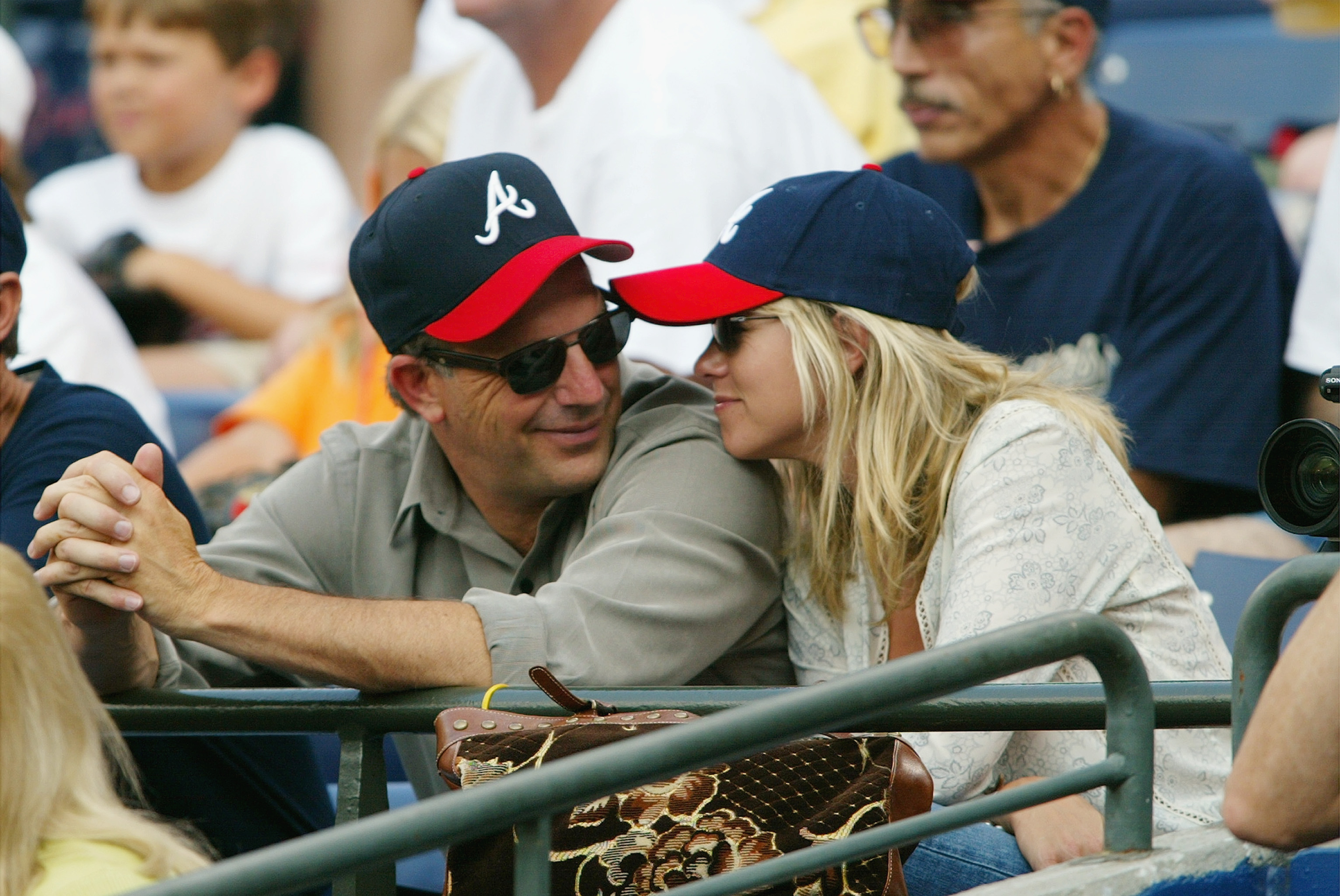 Kevin Costner and his then-fiancée Christine Baumgartner smile at each other during the game between the Florida Marlins and the Atlanta Braves on July 23, 2003 at Turner Field in Atlanta, Georgia. | Source: Getty Images