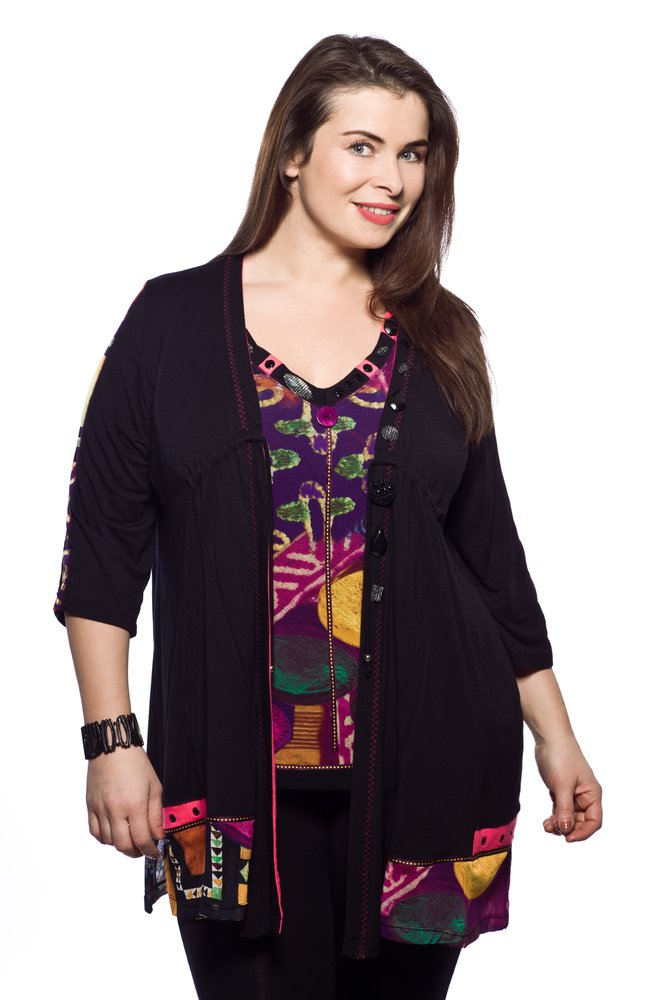 Mujer usando un cárdigan negro con mangas por debajo de los codos y una blusa estampada debajo. | Foto: Shutterstock