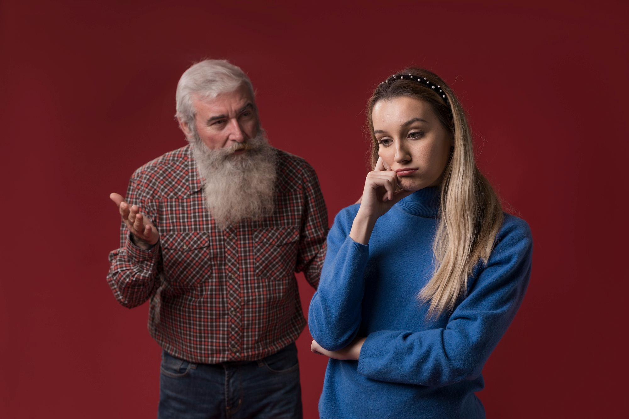 An adult daughter uninterested in what her father has to say | Source: Freepik