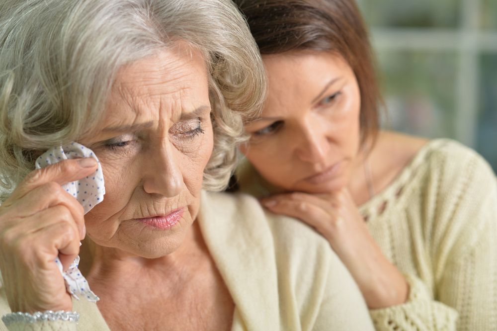 A mother tearing up while her daughter sits beside her. | Source: Getty Images