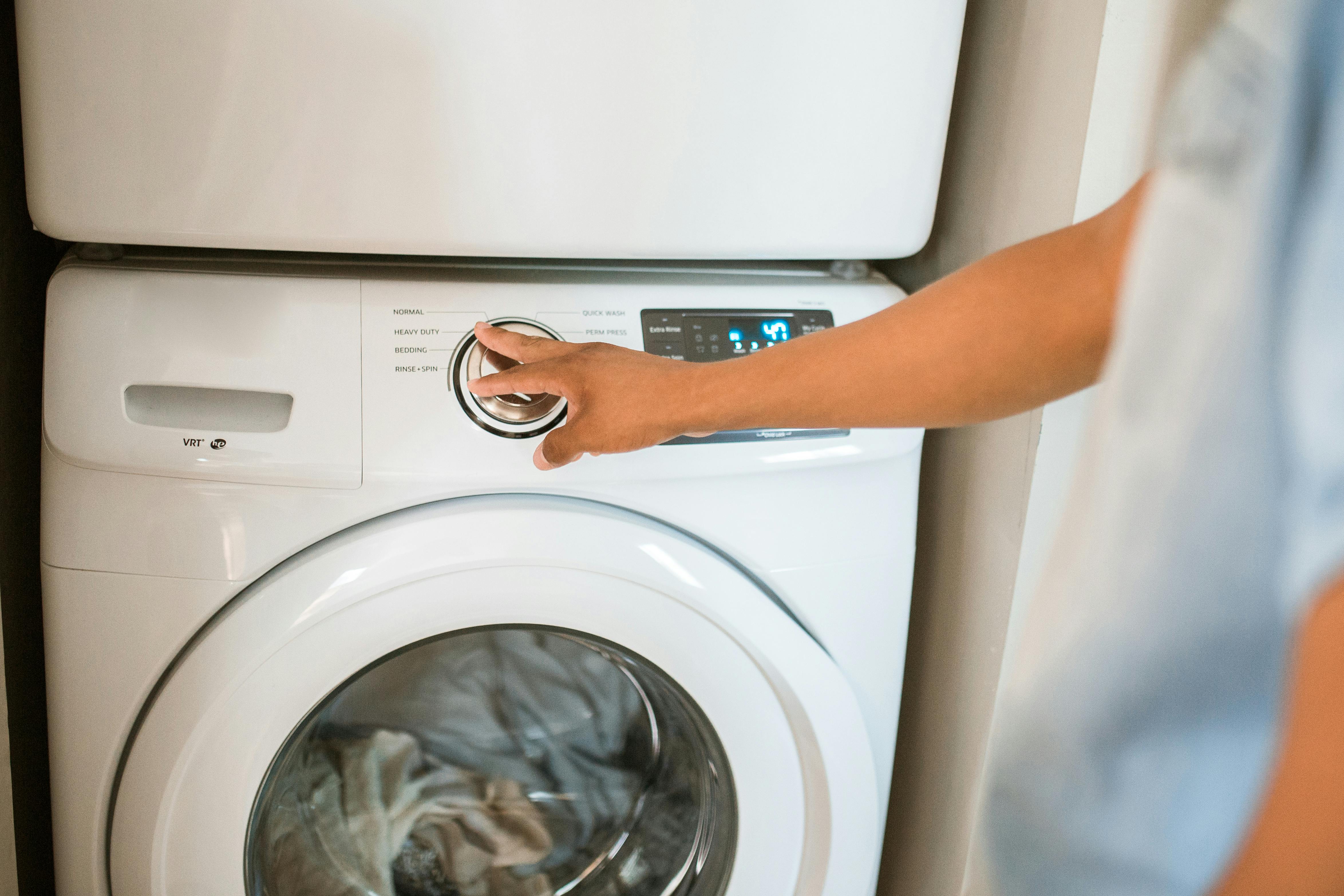 A person operating a washing machine | Source: Pexels