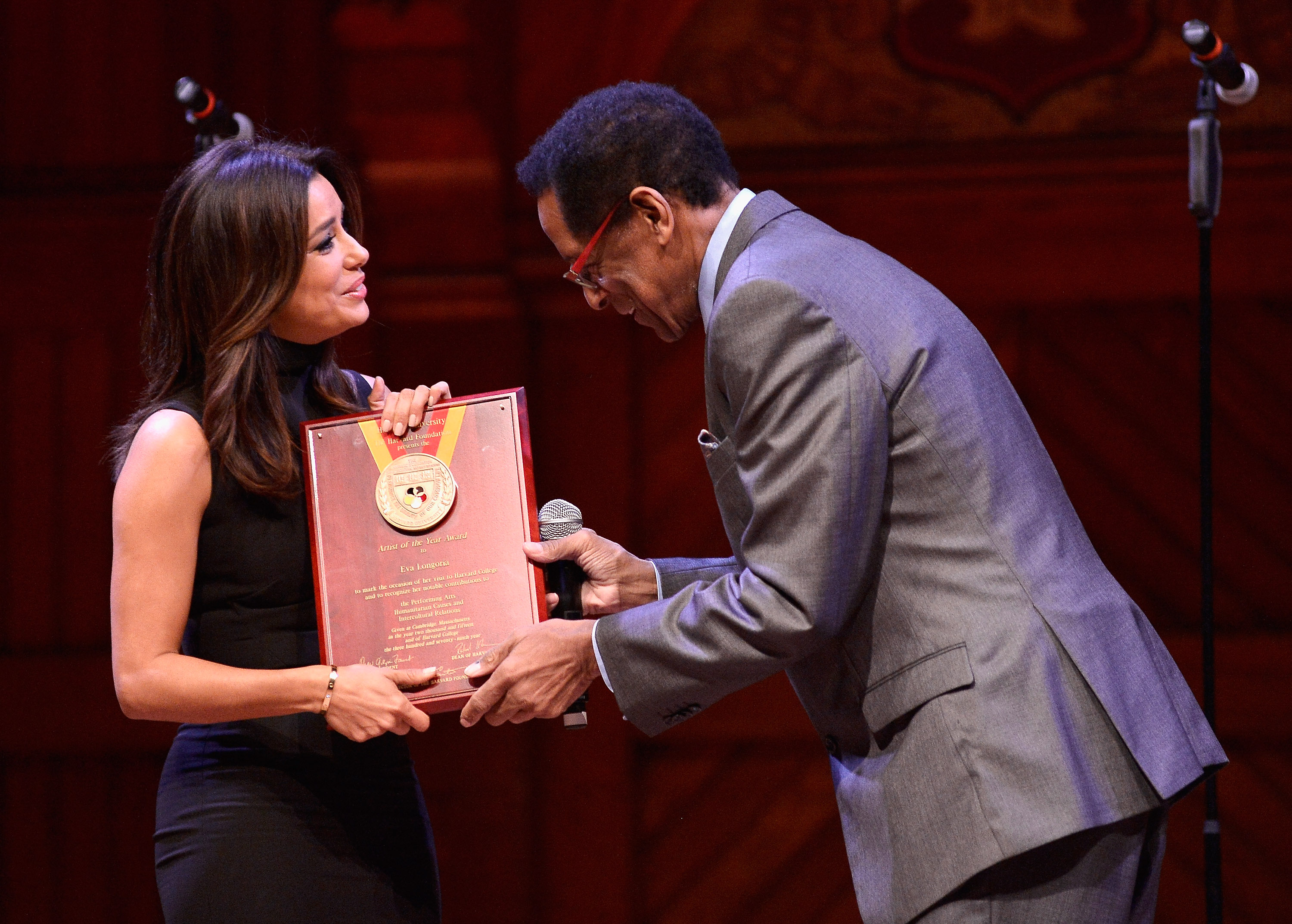 Eva Longoria receives the Harvard University Artist of the Year Award from Harvard Foundation Director Dr. S. Allen Counter in Cambridge, Massachusetts, on February 21, 2015. | Source: Getty Images