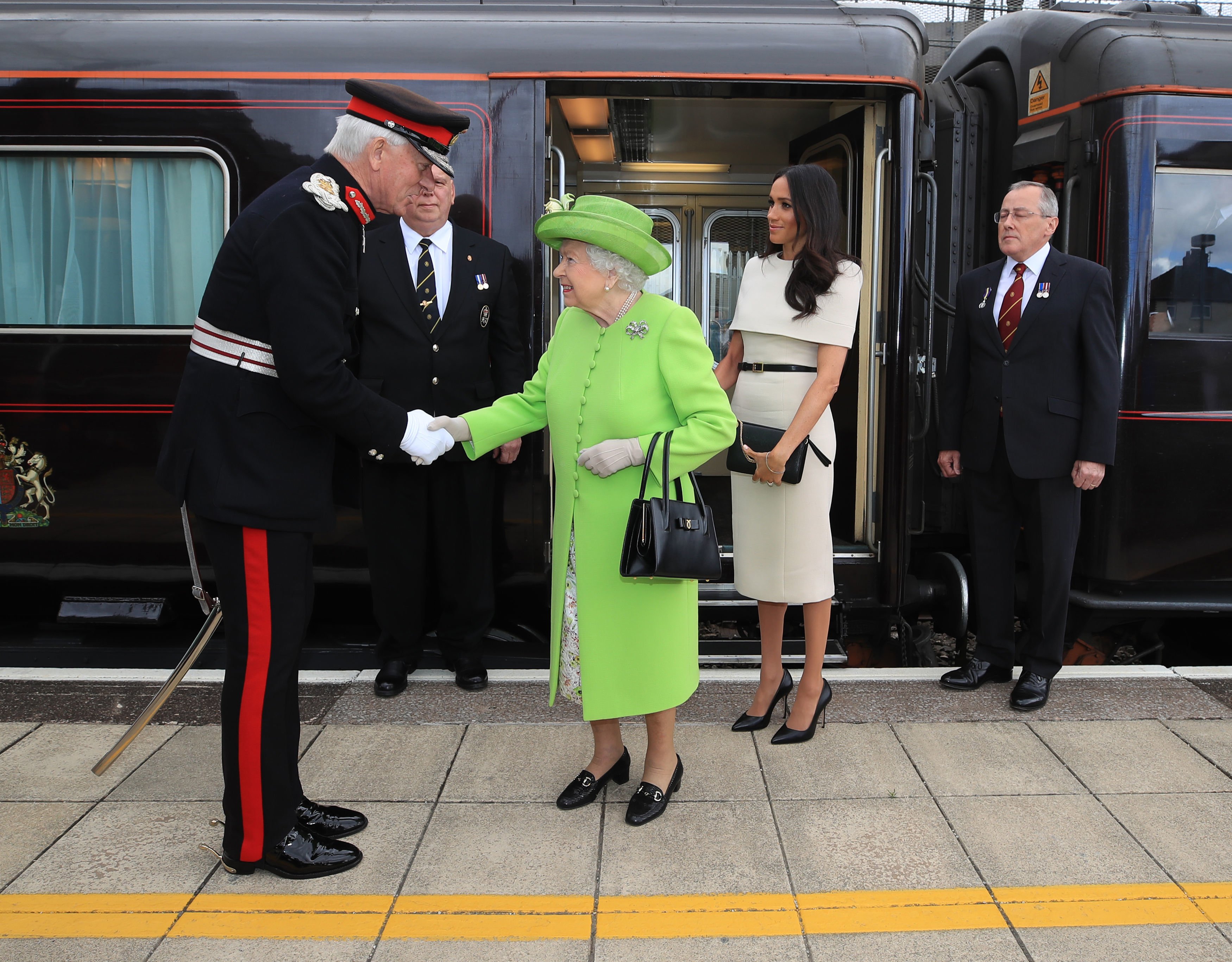 La reina Elizabeth II es recibida por la duquesa Meghan cuando llegan en tren real a la estación Runcorn para abrir el nuevo puente Mersey Gateway el 14 de junio de 2018 en Runcorn, Cheshire, Inglaterra | Foto: Getty Images