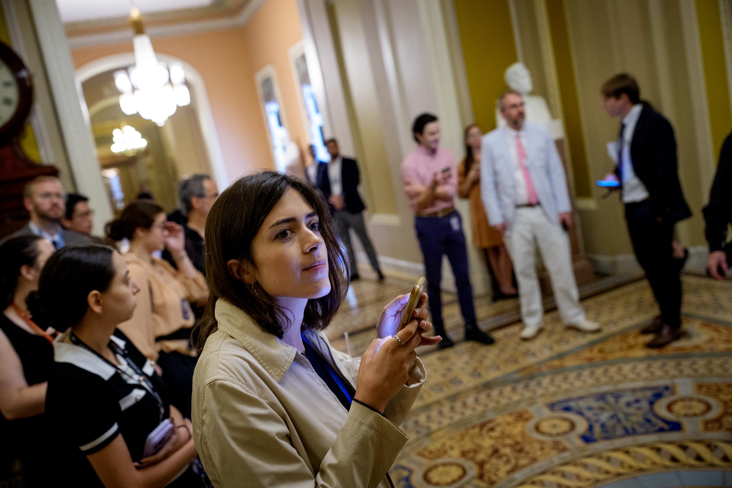 Reporters wait outside the Senate Chamber as the Senate stayed in session throughout the night at the U.S. Capitol Building on July 1, 2025 in Washington, D.C. | Source: Getty Images