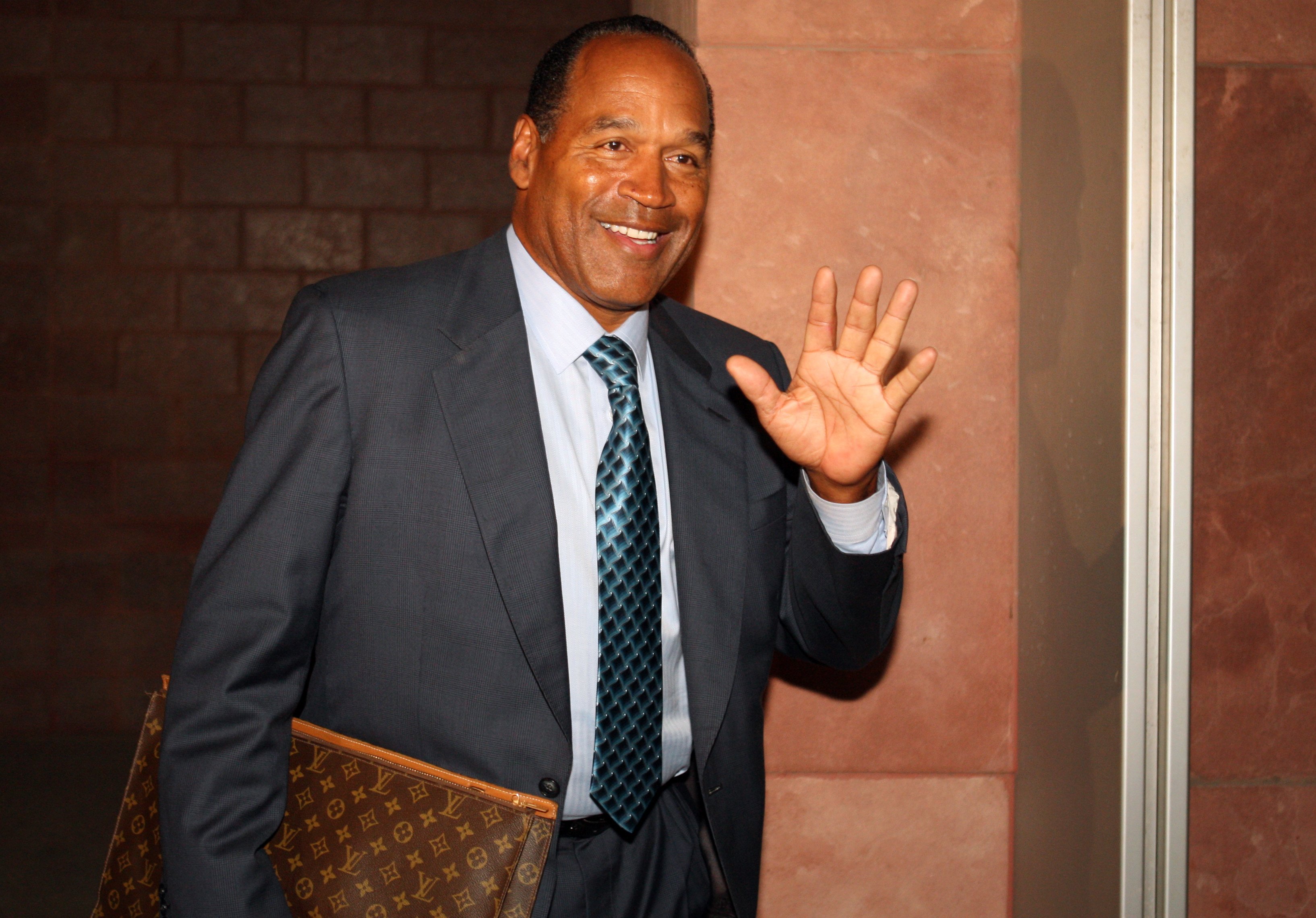 OJ Simpson waves at the press as he leaves the court after the closing arguments during his 2008 trial for felony kidnapping and armed robbery. | Photo: Getty Images