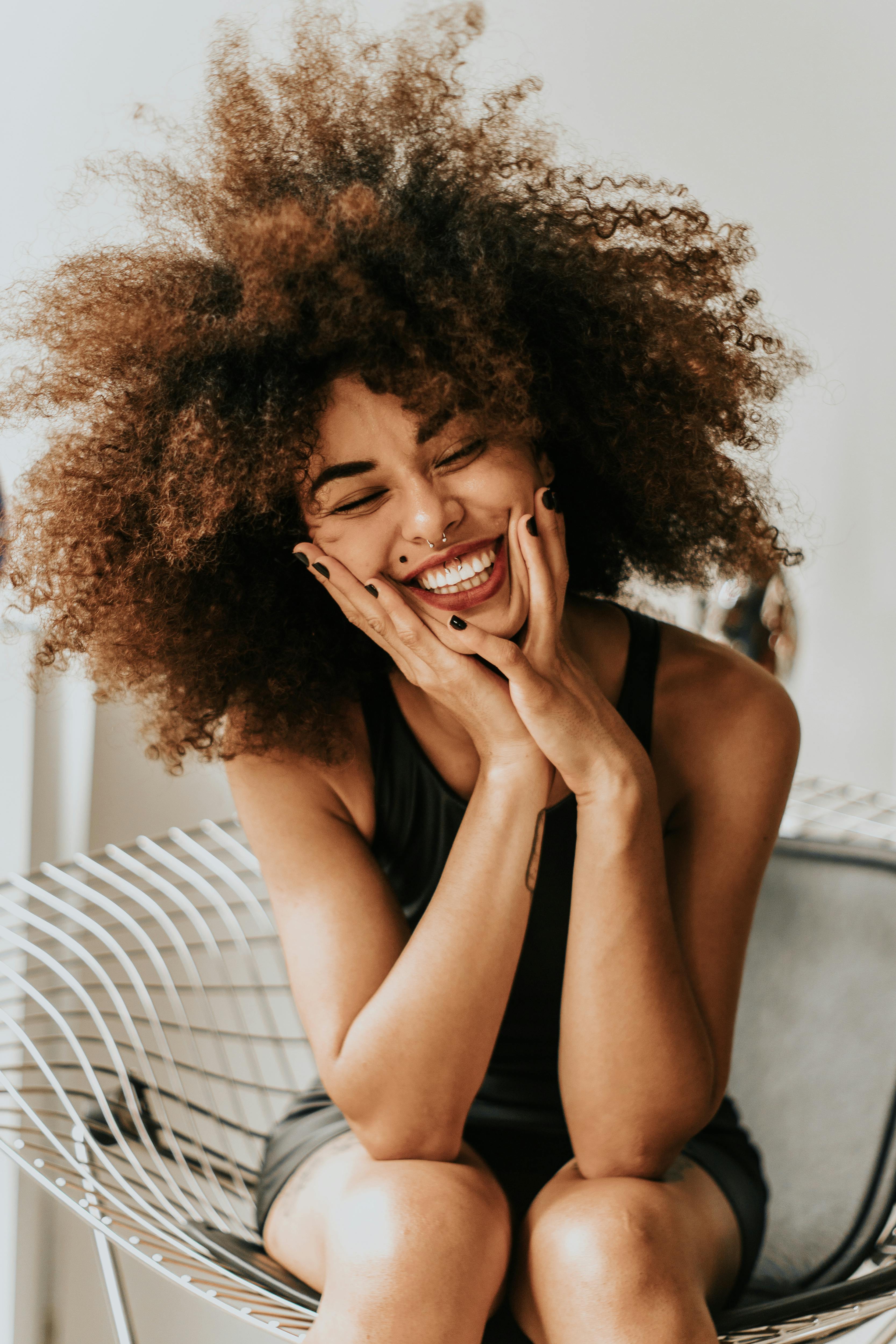 An excited, smiling woman holding her face | Source: Pexels