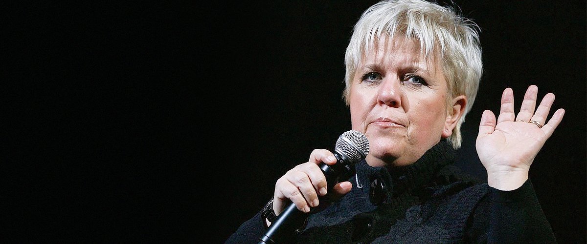 Mimie Mathy lève la main qui porte un micro. | Photo : GettyImage Mimie Mathy lève la main qui porte un micro. | Photo : GettyImage