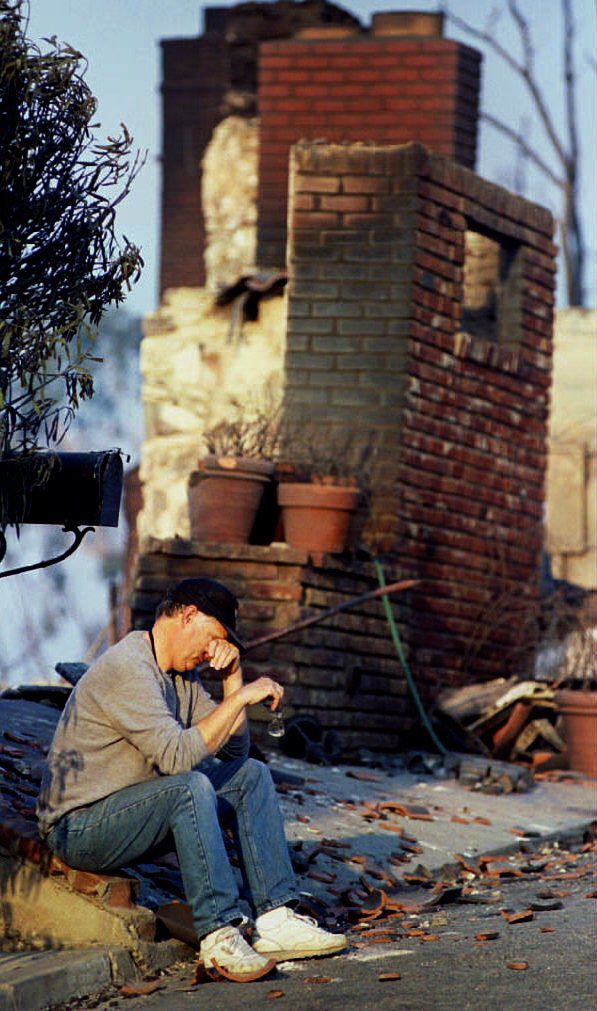 Don Parmiter, a local resident, sitting among the ruins of neighbor Ali MacGraw's Malibu house on November 2, 1993. | Source: Denis Poroy/AFP/Getty Images