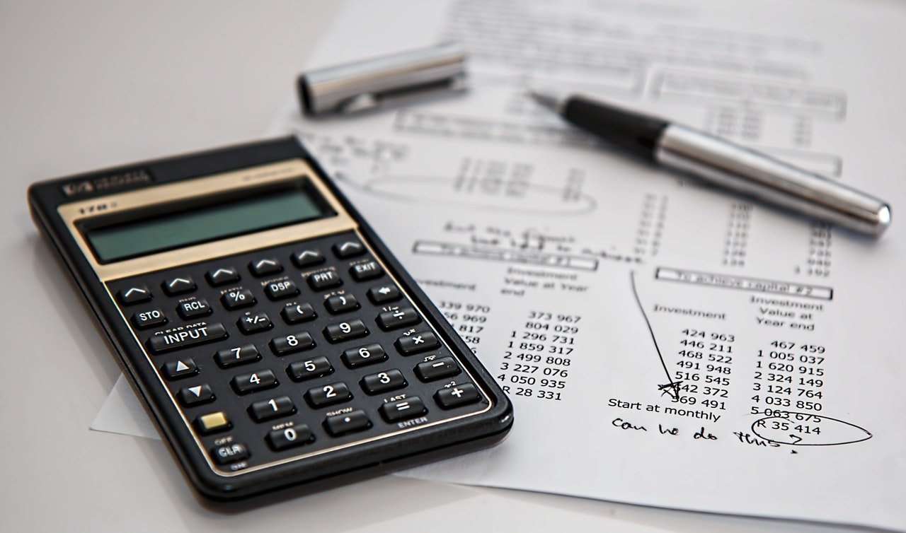 Black calculator and silver pen on a white piece of paper | Source: Pexels