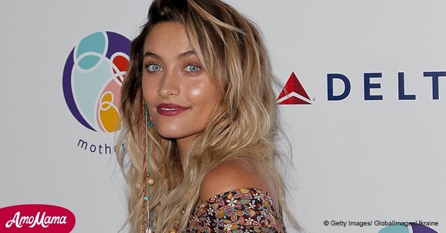 Paris Jackson shows off her many tattoos on arms, chest, and shoulders in a floral plunging dress