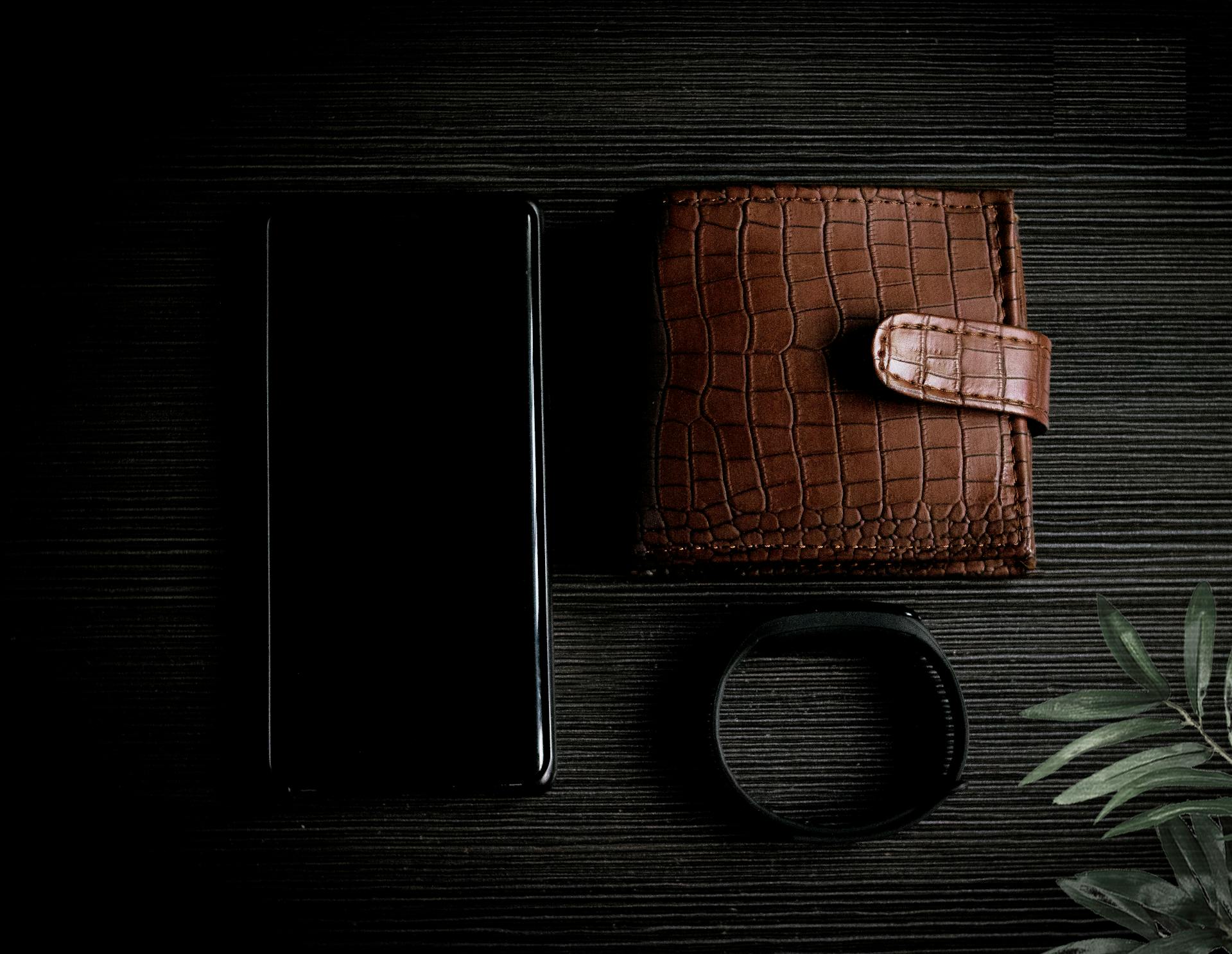 A wallet, phone and bracelet on a table | Source: Pexels