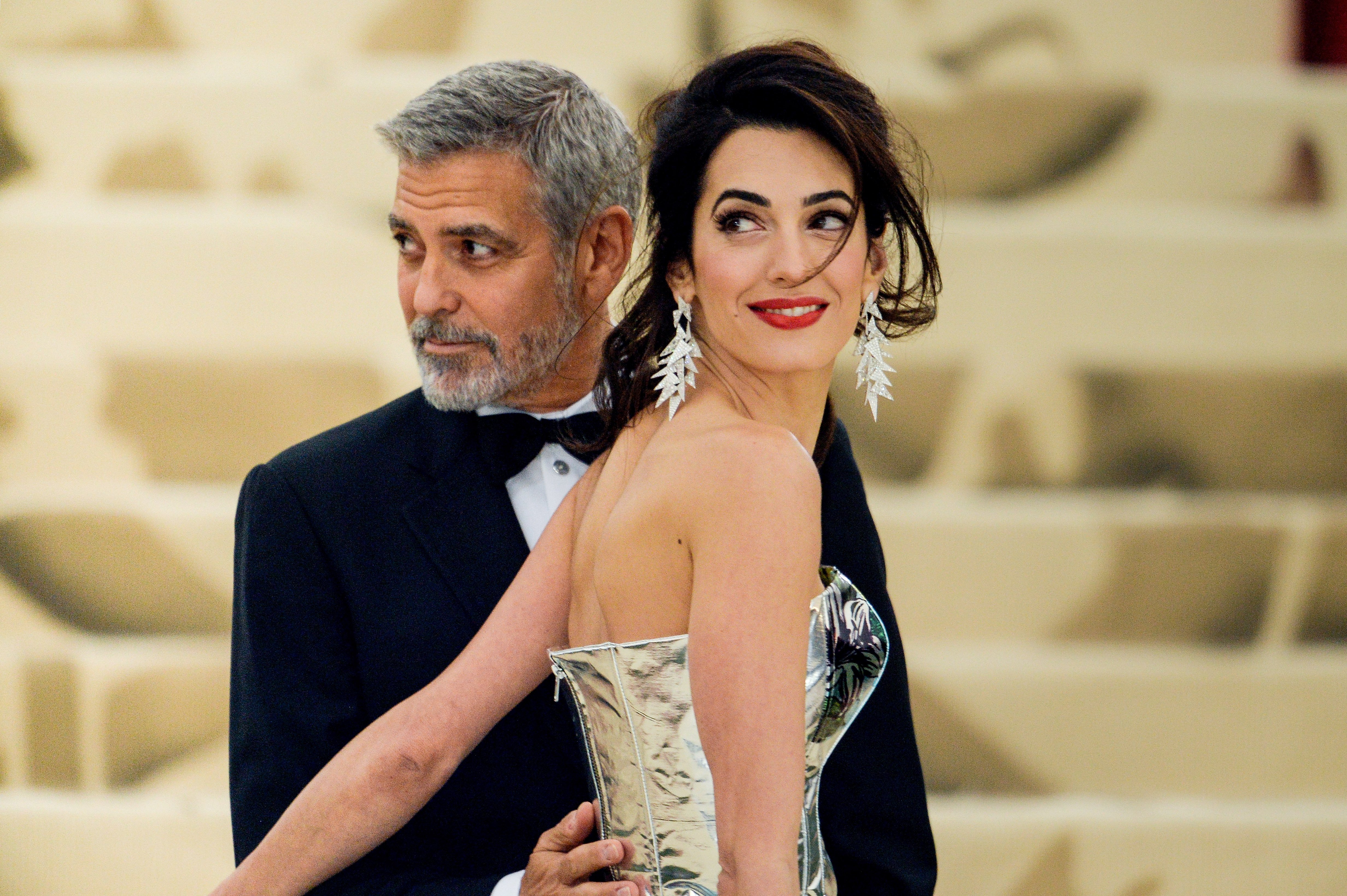 George Clooney and Amal Clooney enter the Heavenly Bodies: Fashion & The Catholic Imagination Costume Institute Gala at The Metropolitan Museum on May 07, 2018 in New York City | Source: Getty Images