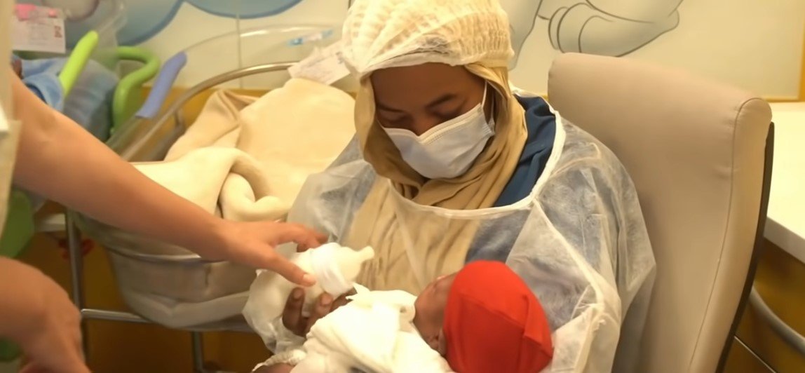 Picture of Halima Cisse feeding one of her babies | Source: Youtube/ ABC News 