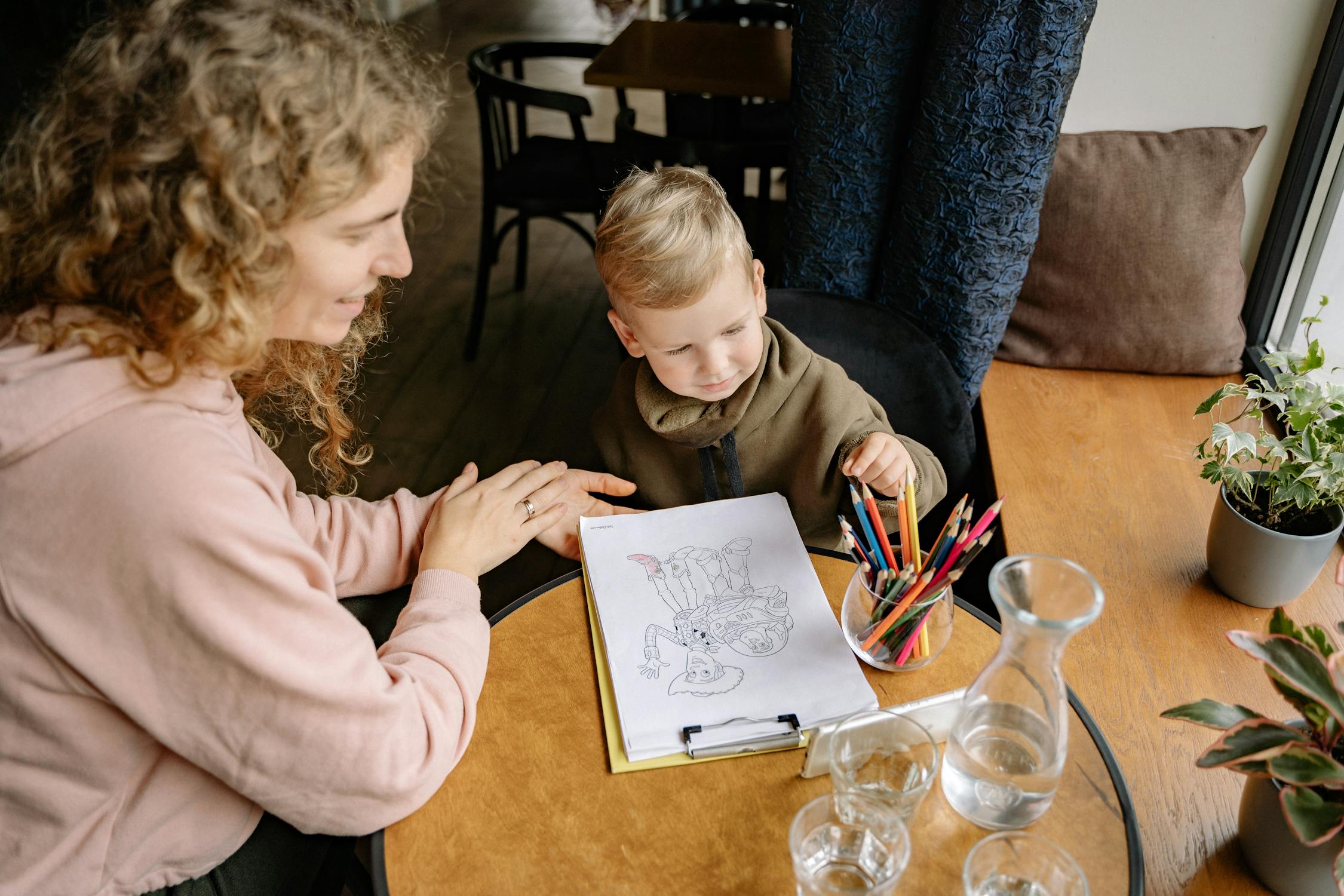 A woman and a boy coloring a coloring book | Source: Pexels