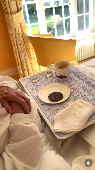 A wider shot captures the full breakfast arrangement — a cup of coffee, a single chocolate digestive, and the carefully placed napkin — set against a patterned tray. In the background, soft daylight pours through the windows, completing a serene and quietly celebratory start to Lady Pamela Hicks's milestone birthday. | Source: Instagram/indiahicksstyle