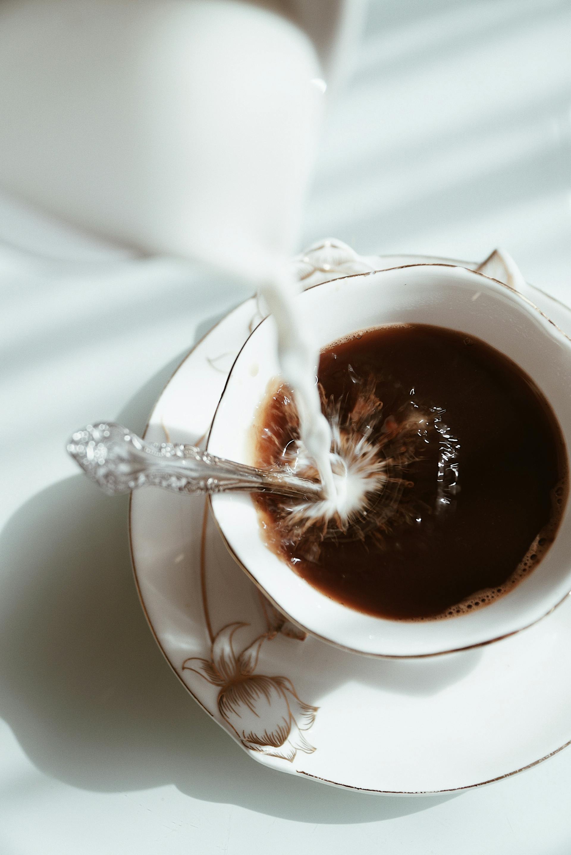 Milk being poured into coffee | Source: Pexels