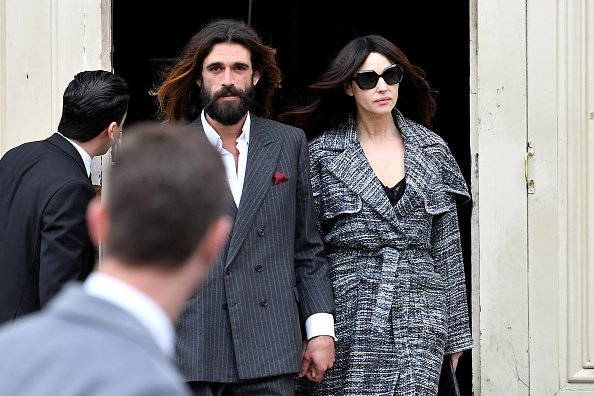 Nicolas Lefebvre and Monica Bellucci holding hands at the Chanel show | Photo: Getty Images