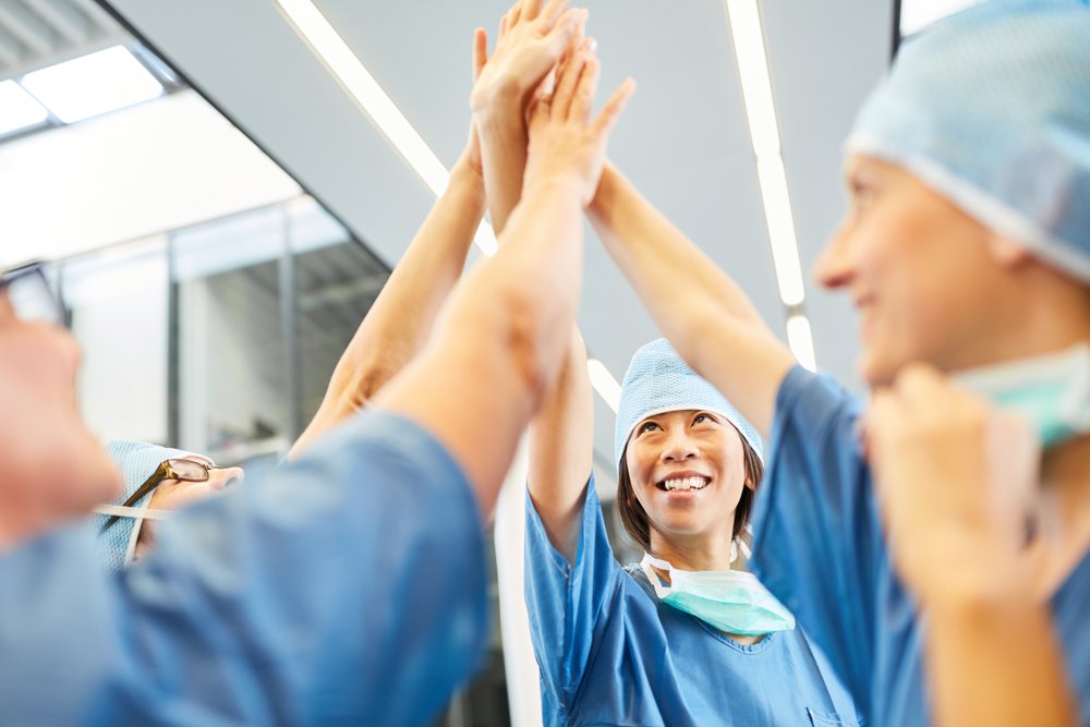 Surgeons high-five each other during their discussion on their best patients | Photo: Shutterstock