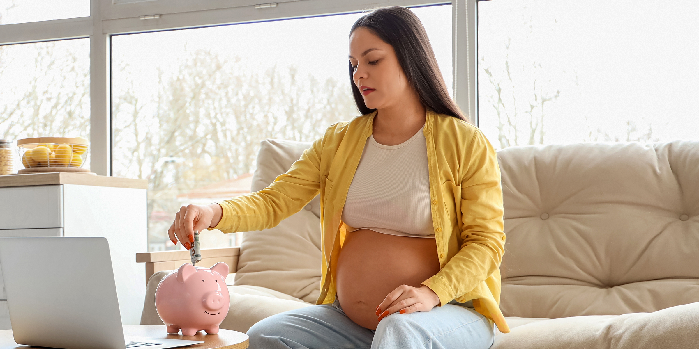 A pregnant woman saving money in a piggy bank | Source: Shutterstock