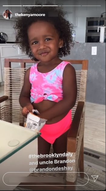 Kenya Moore's daughter, Brooklyn, dressed in pink underwear and a pink and white crop top seen playing with her uncle | Photo: Instagram/thekenyamoore