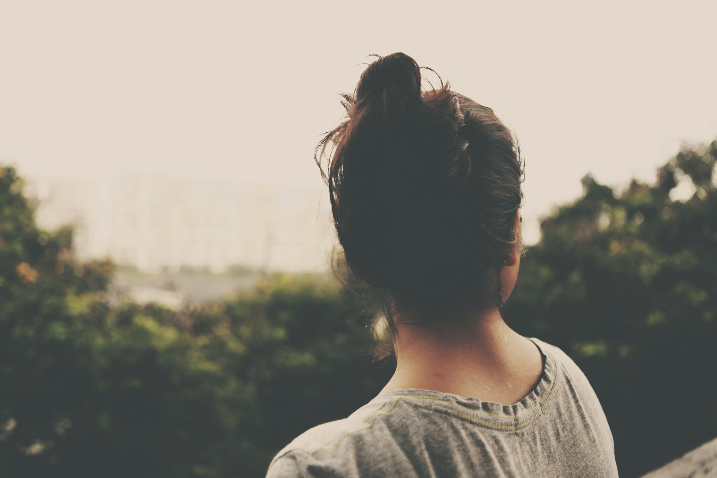 A woman sitting outside looking at the trees | Source: Unsplash