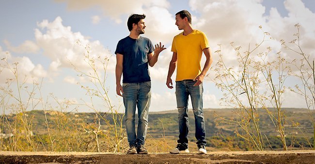 Two young men talking. | Source: Shutterstock