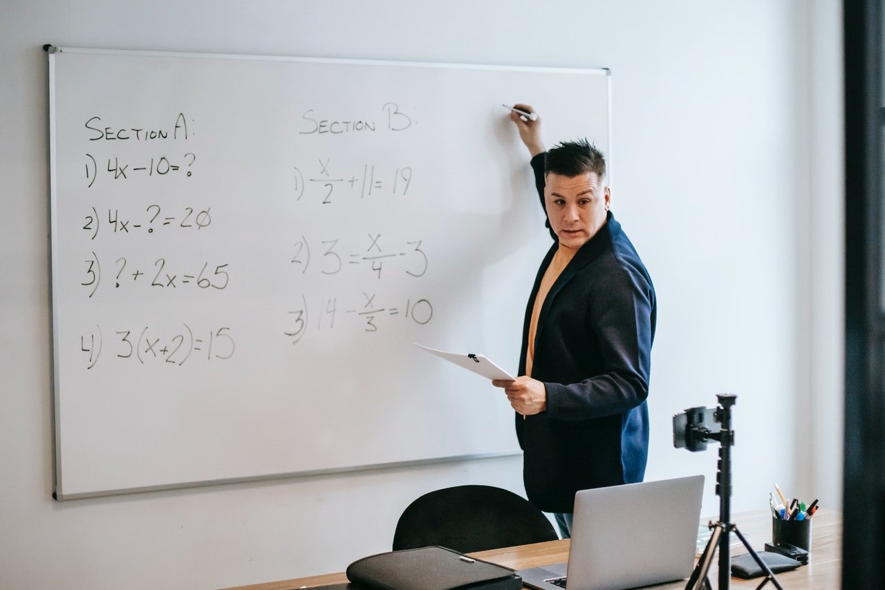 Photo of a teacher writing on a whiteboard | Photo: Pexels