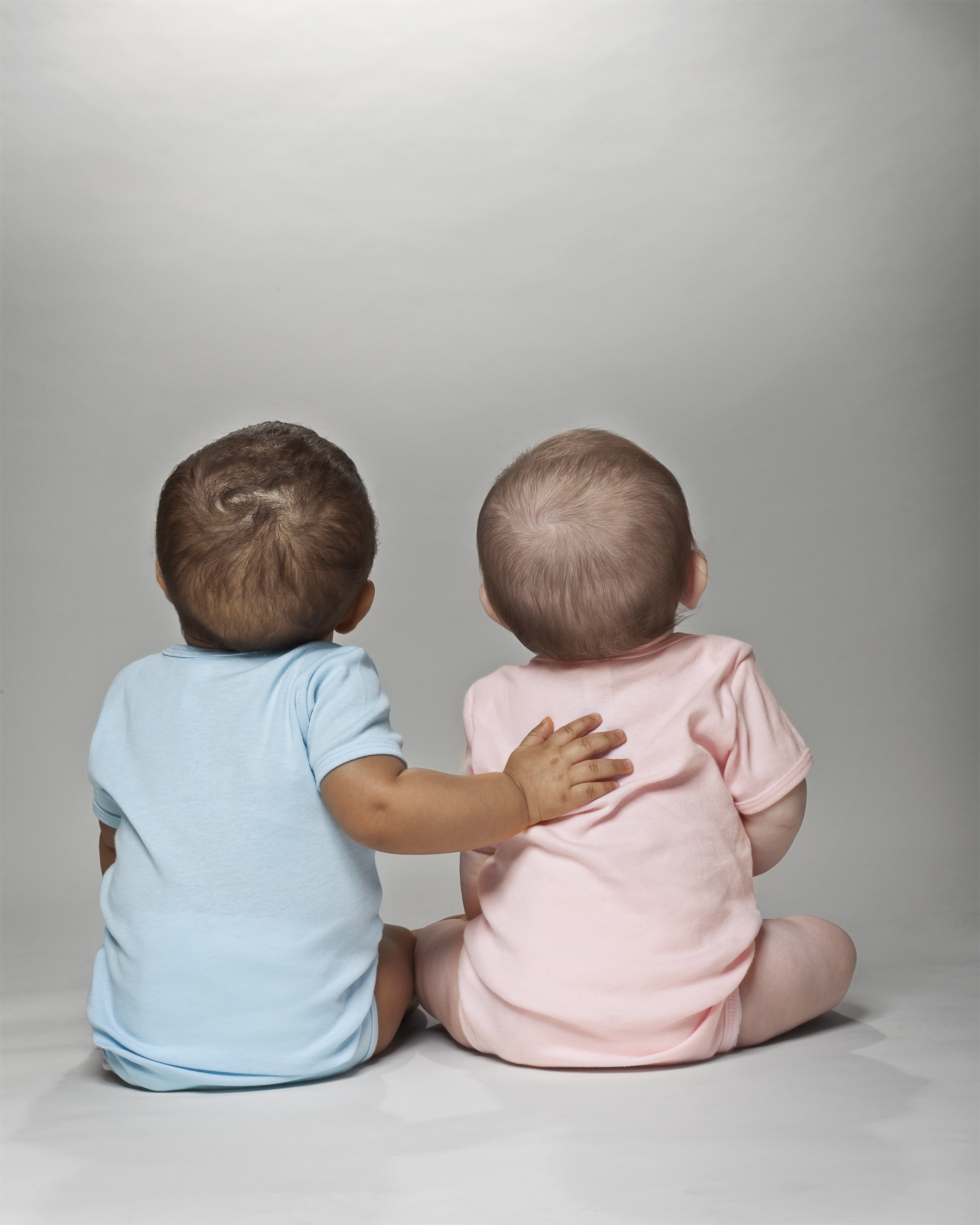 Two babies sit on the floor together. | Source: Getty Images