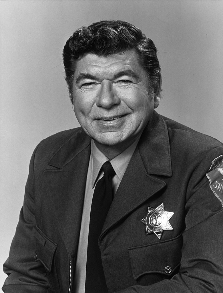 Claude Akins vistiendo su uniforme y placa como Sheriff Lobo de la serie de televisión, “Billy Joe y su mono”. | Foto: Getty Images