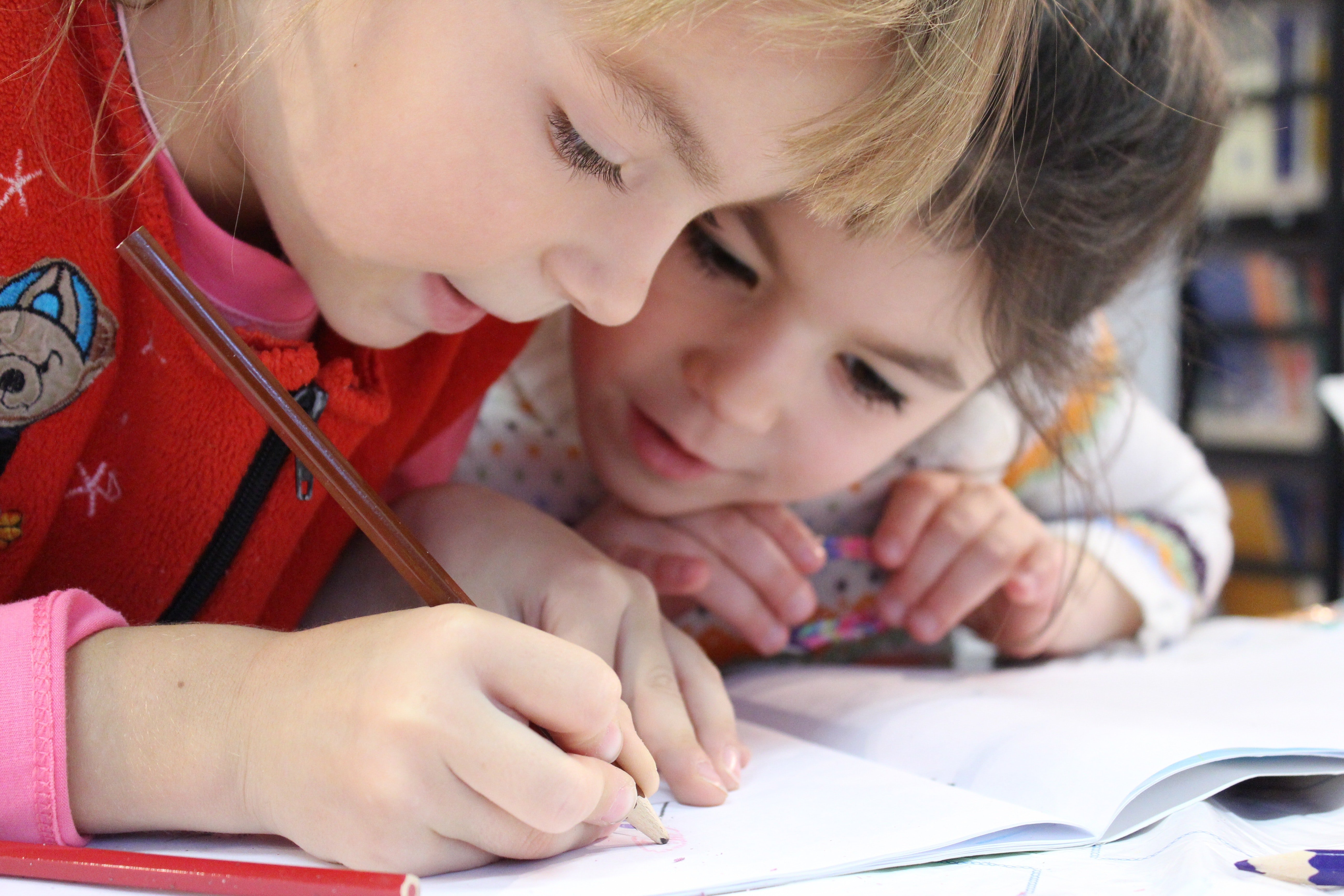 Children writing down their answers. | Source: Pexels