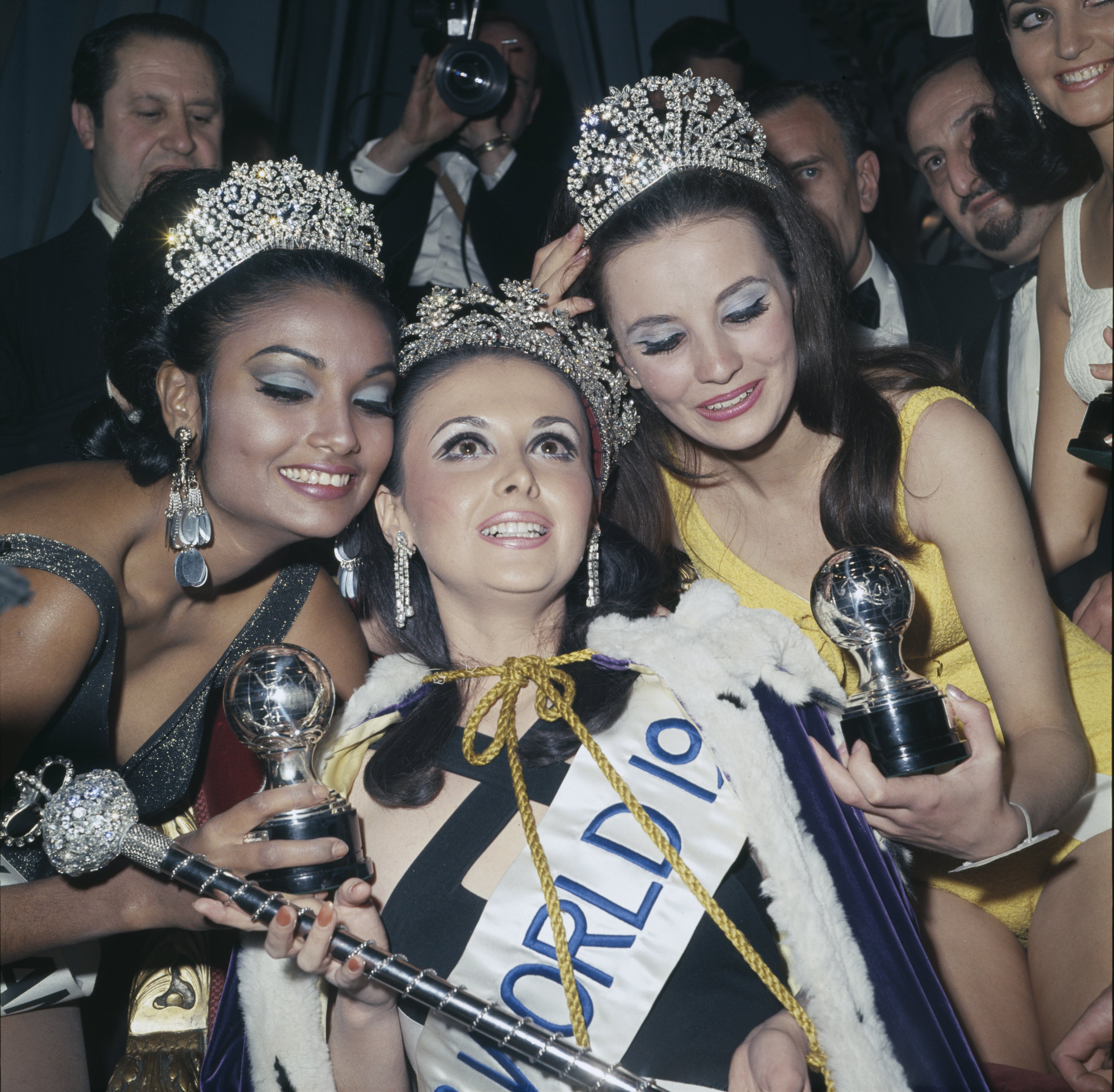Pictured are the 1967 Miss World beauty pageant top three: Madeline Hartog-Bel of Peru (C) in first place, Maria del Carmen Sabaliauskas (R) in second place, and Shakira Baksh (L) in third place. The top three were pictured at the Lyceum Ballroom in London on 16th November 1967. | Source: Getty Images