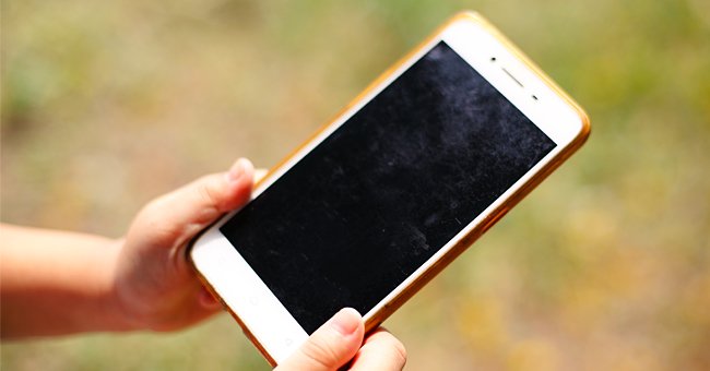 Un téléphone tenu dans une main | Photo : Shutterstock Un téléphone tenu dans une main | Photo : Shutterstock