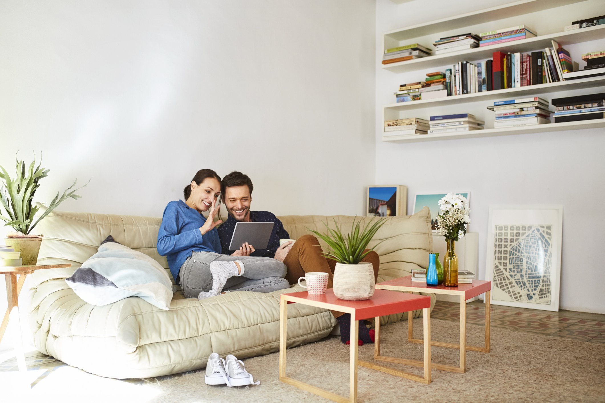 A happy couple relaxing and smiling on the sofa. | Photo: Getty Images